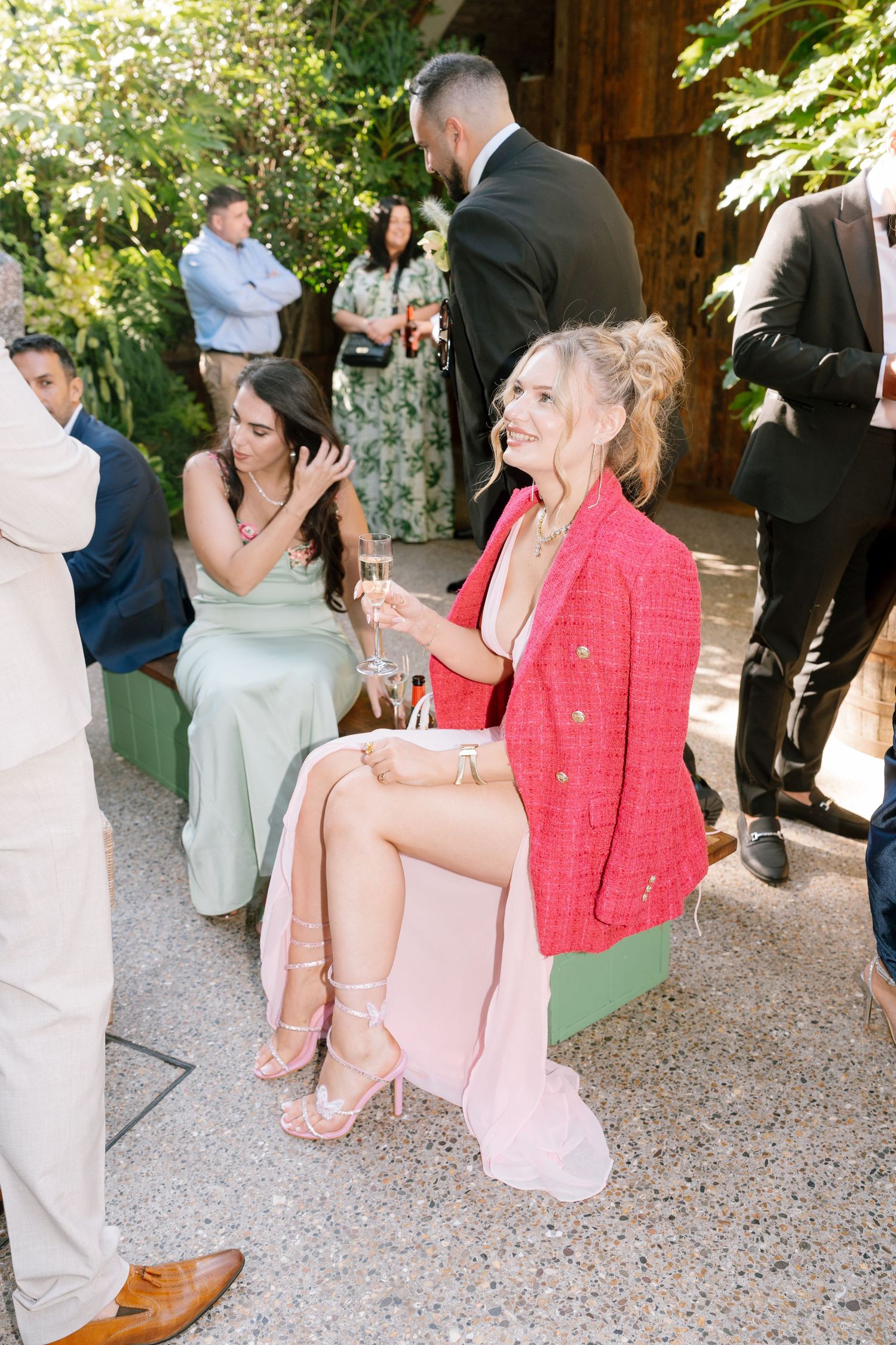 Wedding guests seated outdoors in formal attire during daytime celebration.