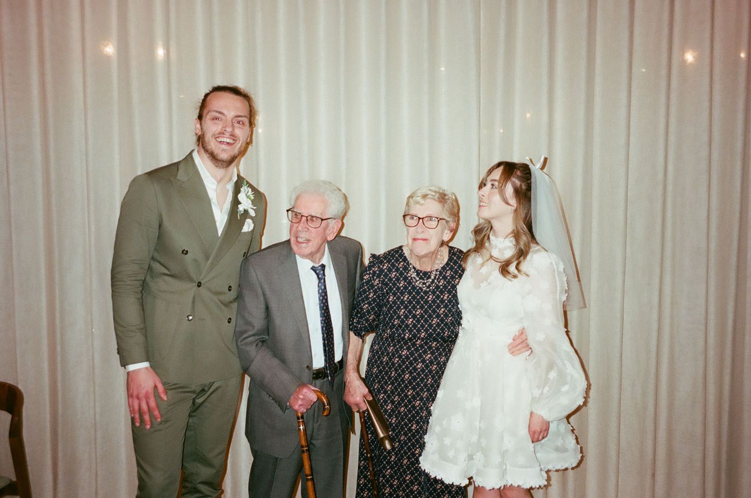 Vintage photo strip showing four connected images of people posing together at a formal event.