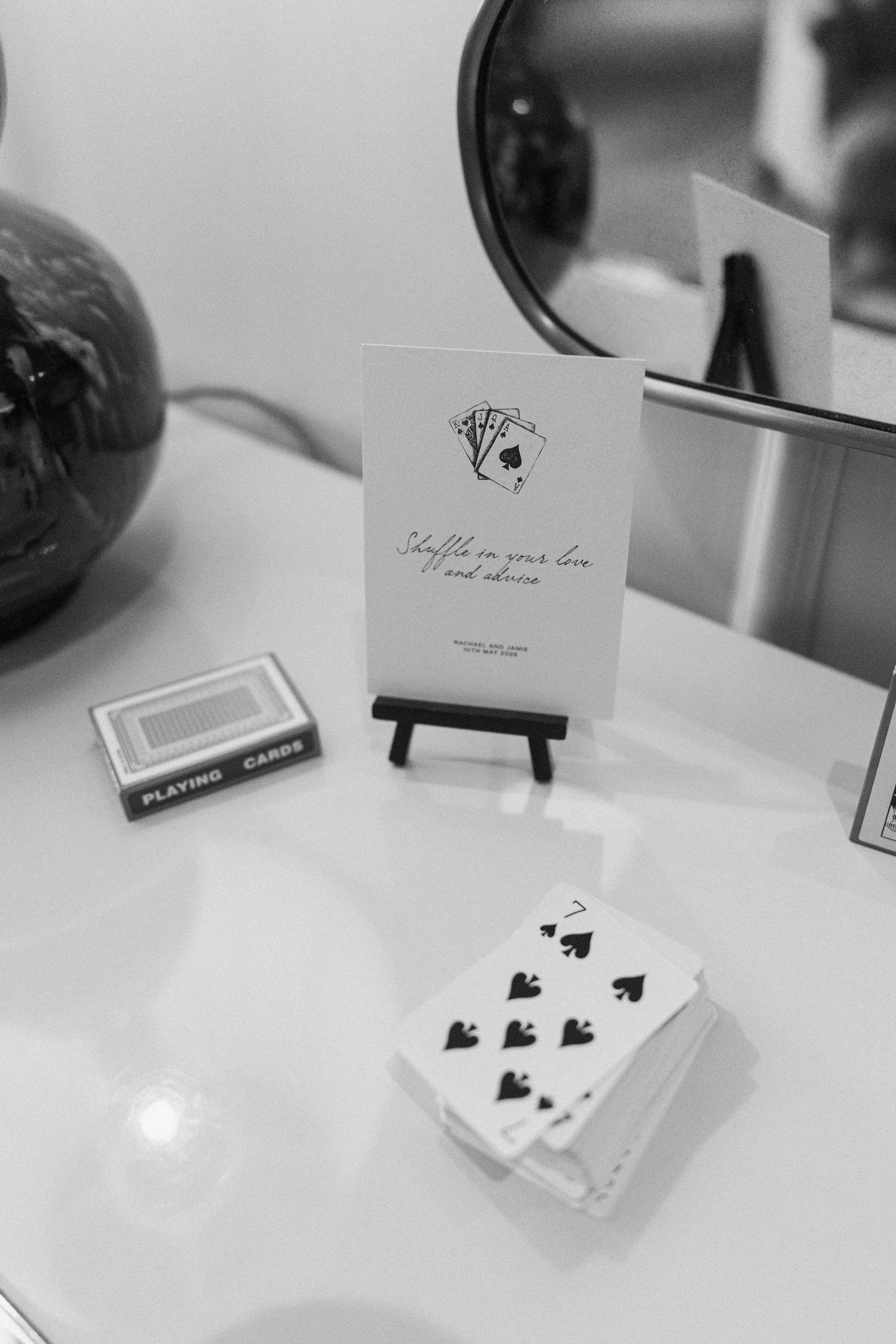 Black and white wedding guest activity with playing cards and shuffle your love advice sign.