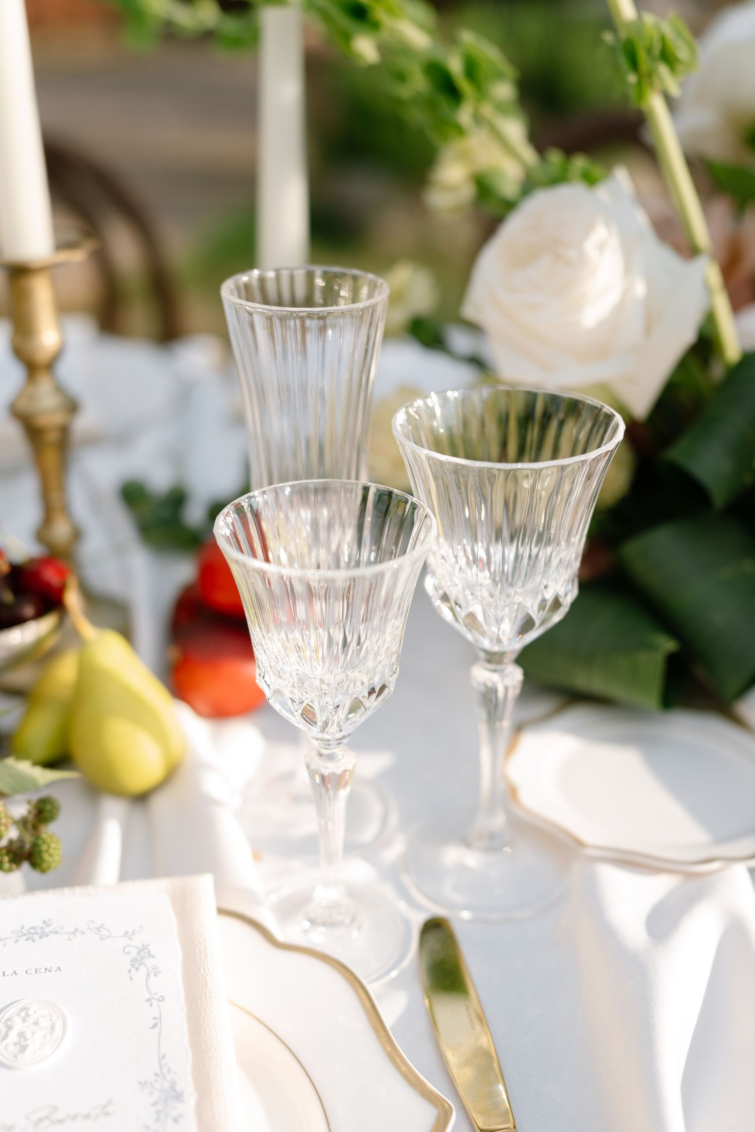 Elegant crystal glasses set on a white tablecloth for a formal dining event.