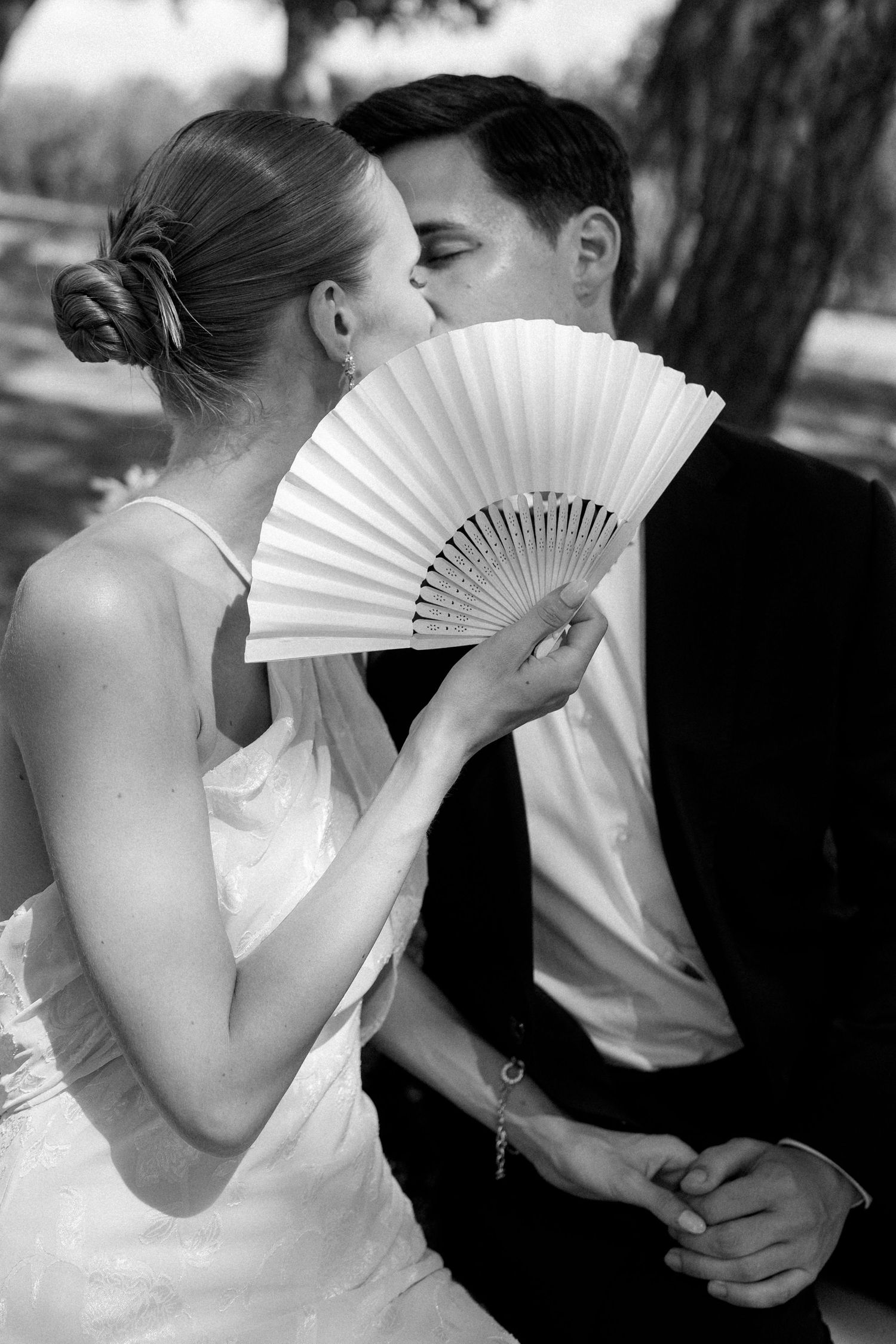 Romantic black and white photos featuring white hand fans and formal attire.