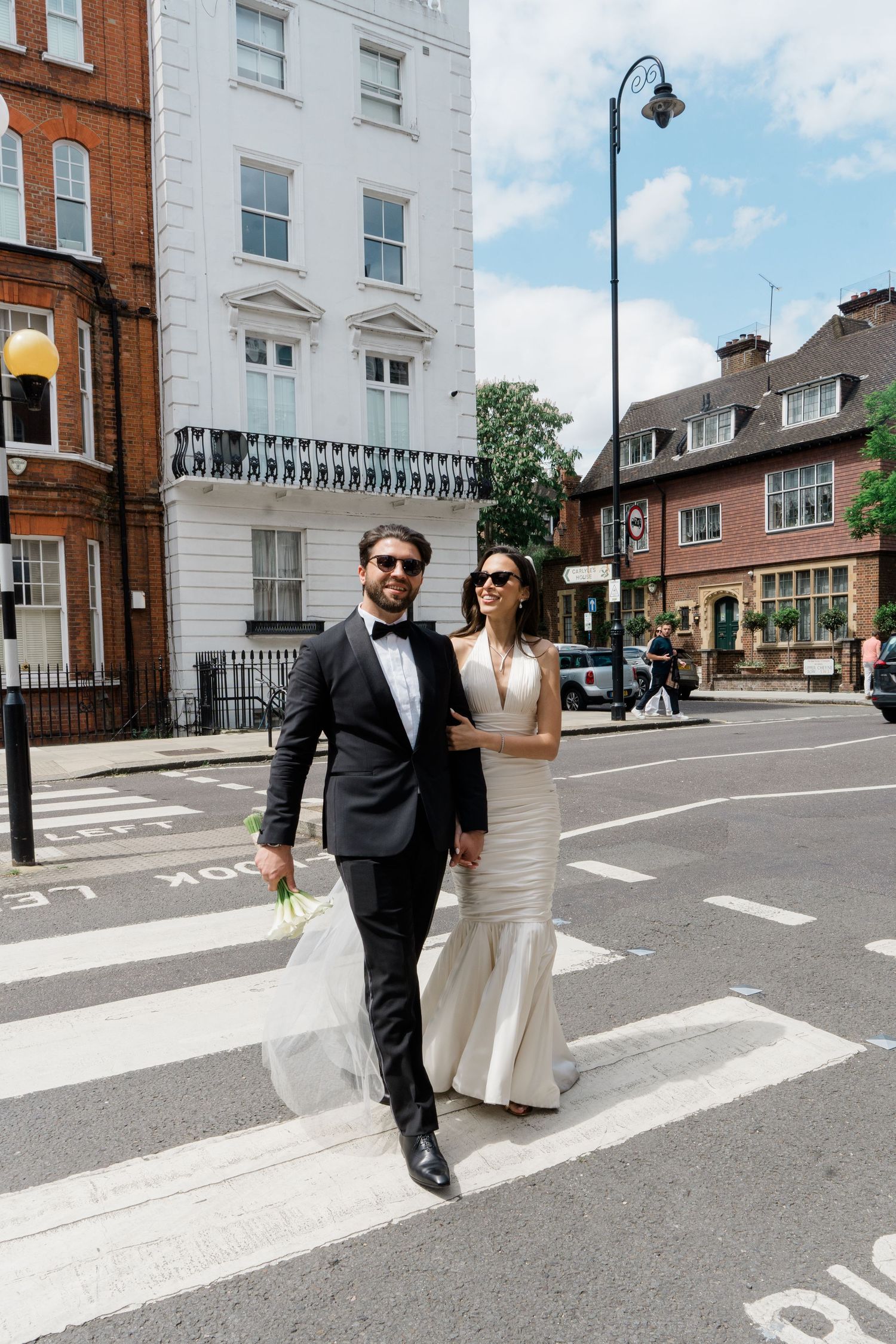 A couple crosses a street in wedding attire on their special day.
