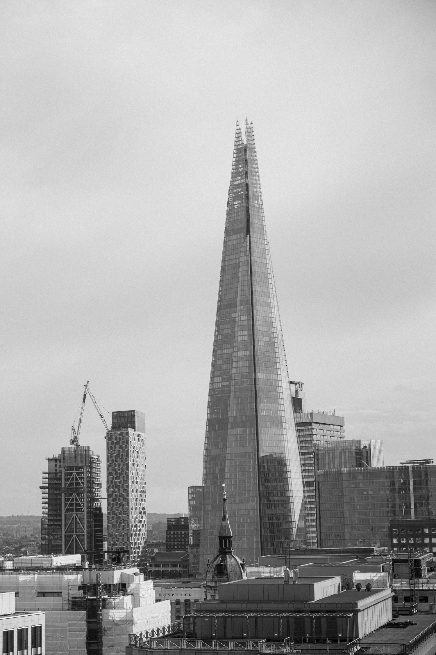 Black and white architectural photo of The Shard towering over London.