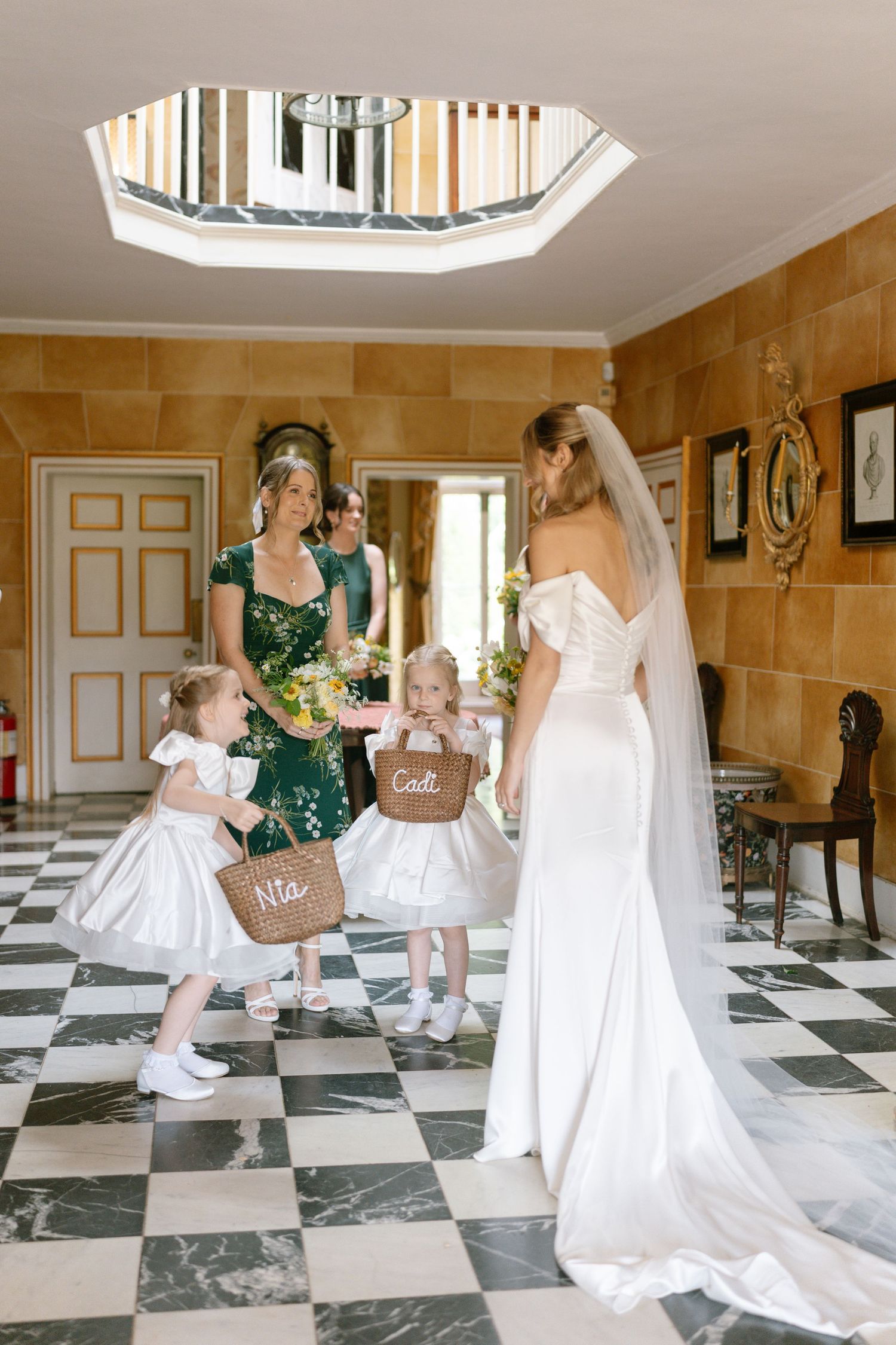 Elegant bridal party in a black and white checkered floor room with ornate decor.