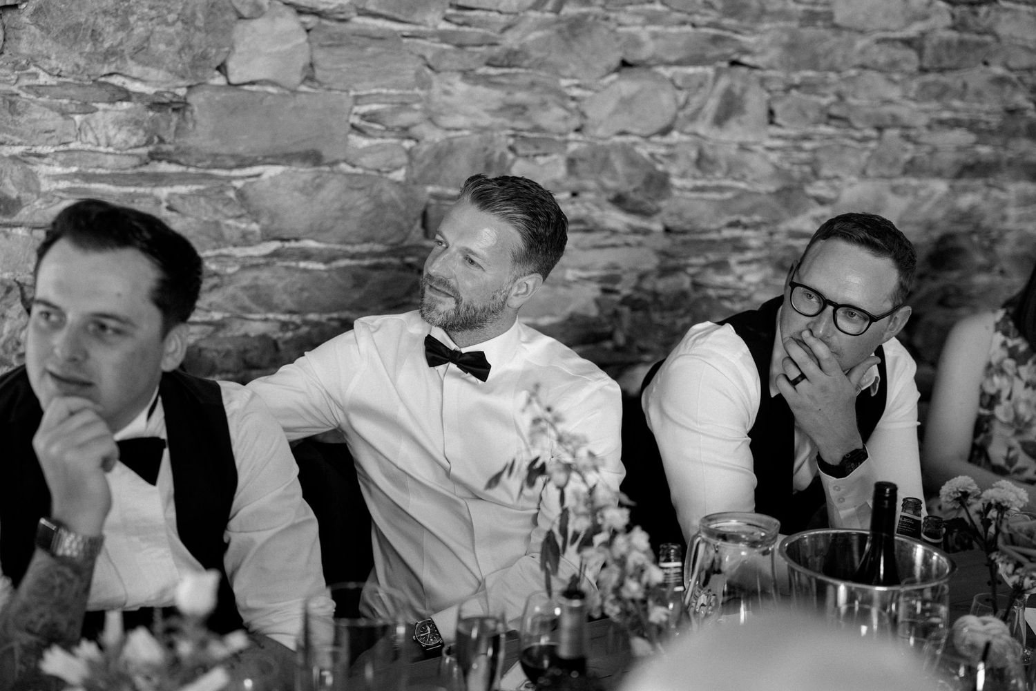 Wedding guests seated at a long table during a reception celebration.