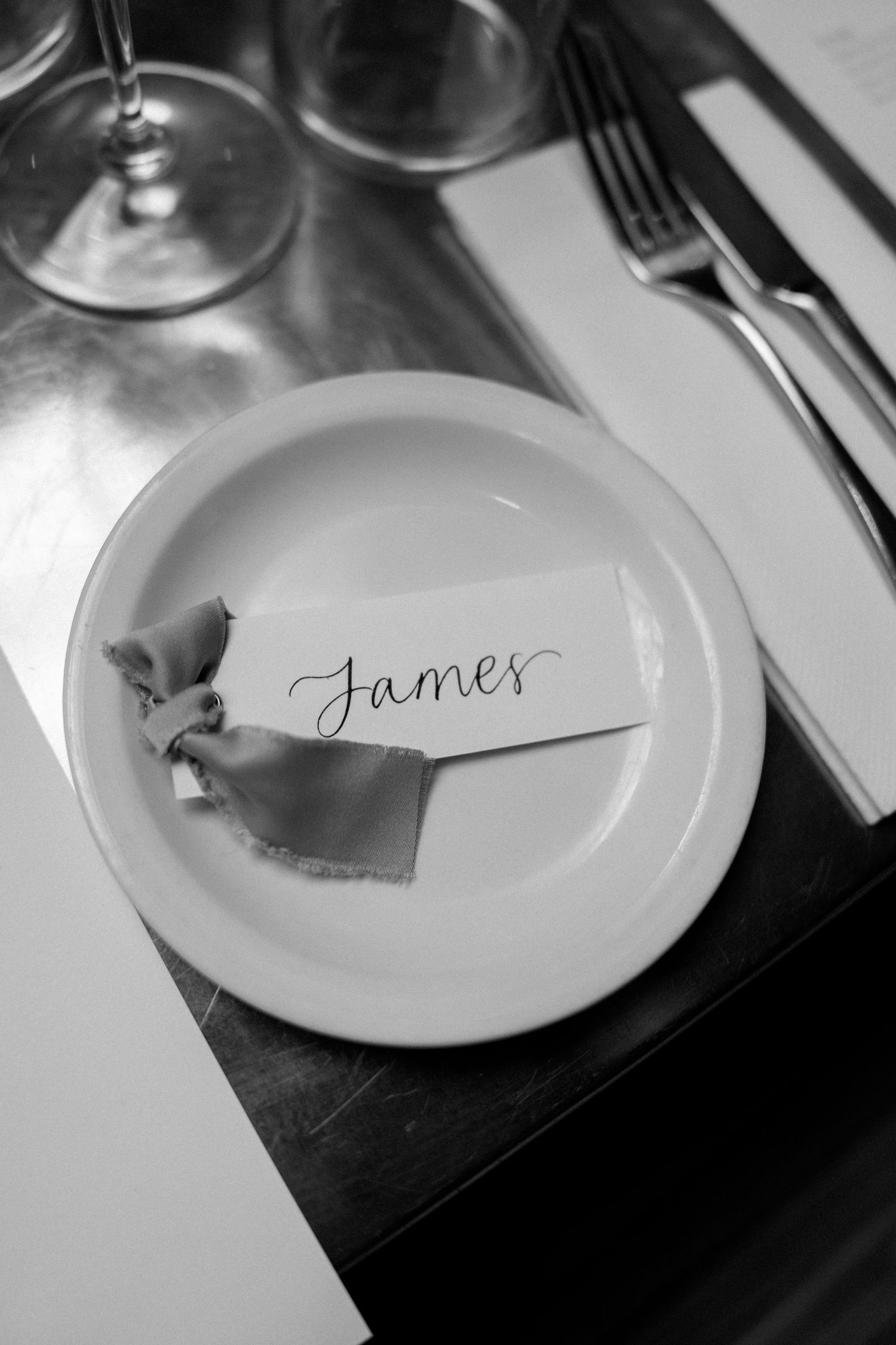 Place setting at formal event with handwritten name card that says James.