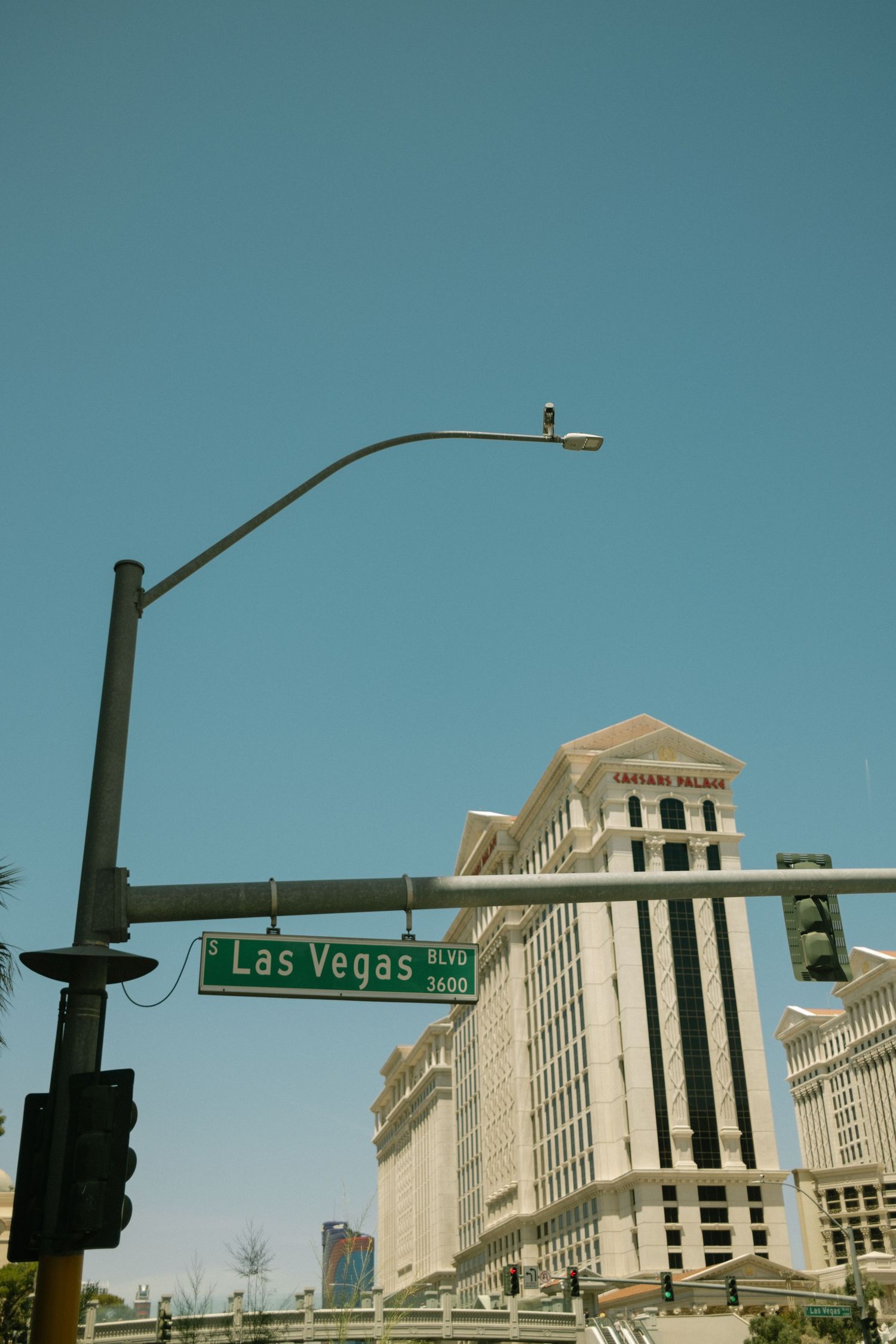 Las Vegas street sign with Caesars Palace hotel and casino buildings visible in the background.