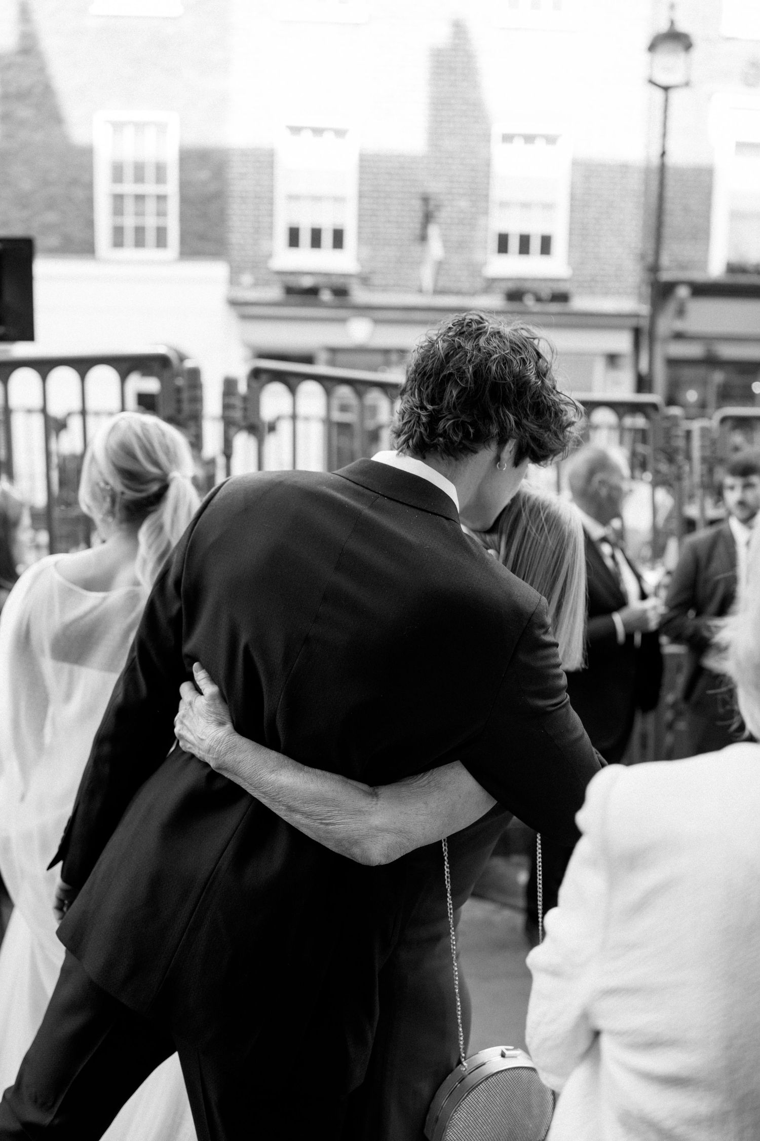 A black and white photo of a couple embracing during their wedding celebration.