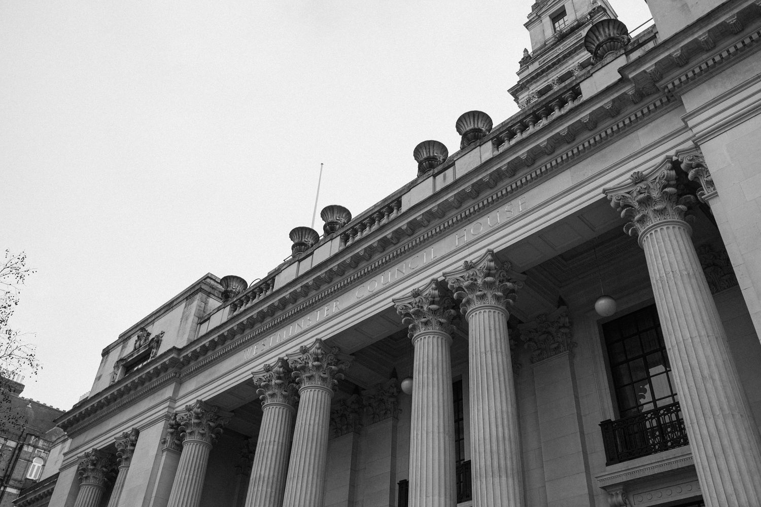Black and white architectural photo of grand neoclassical building with tall Corinthian columns.