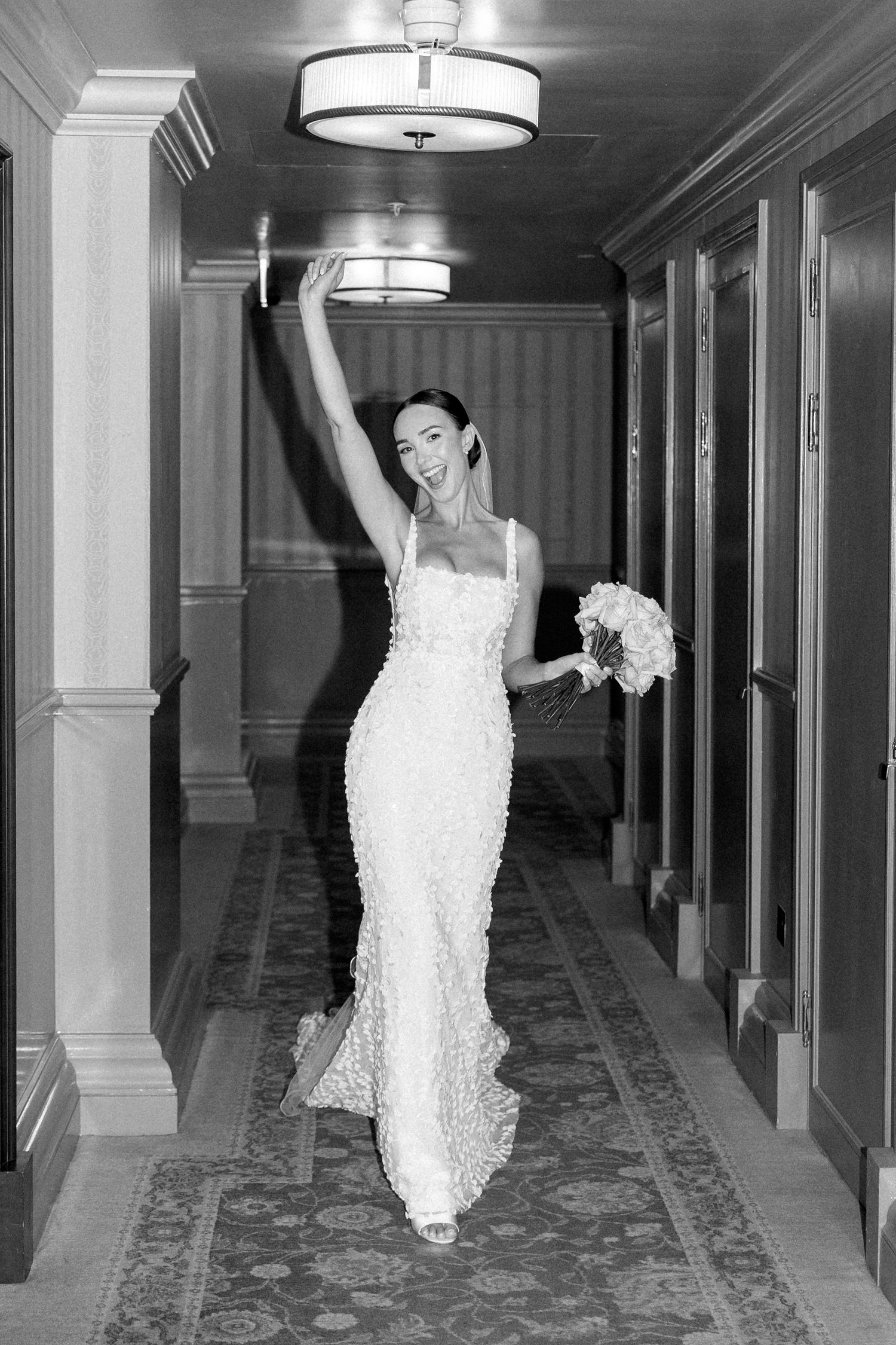 Black and white photo series of a bride dancing and twirling in a luxurious corridor.