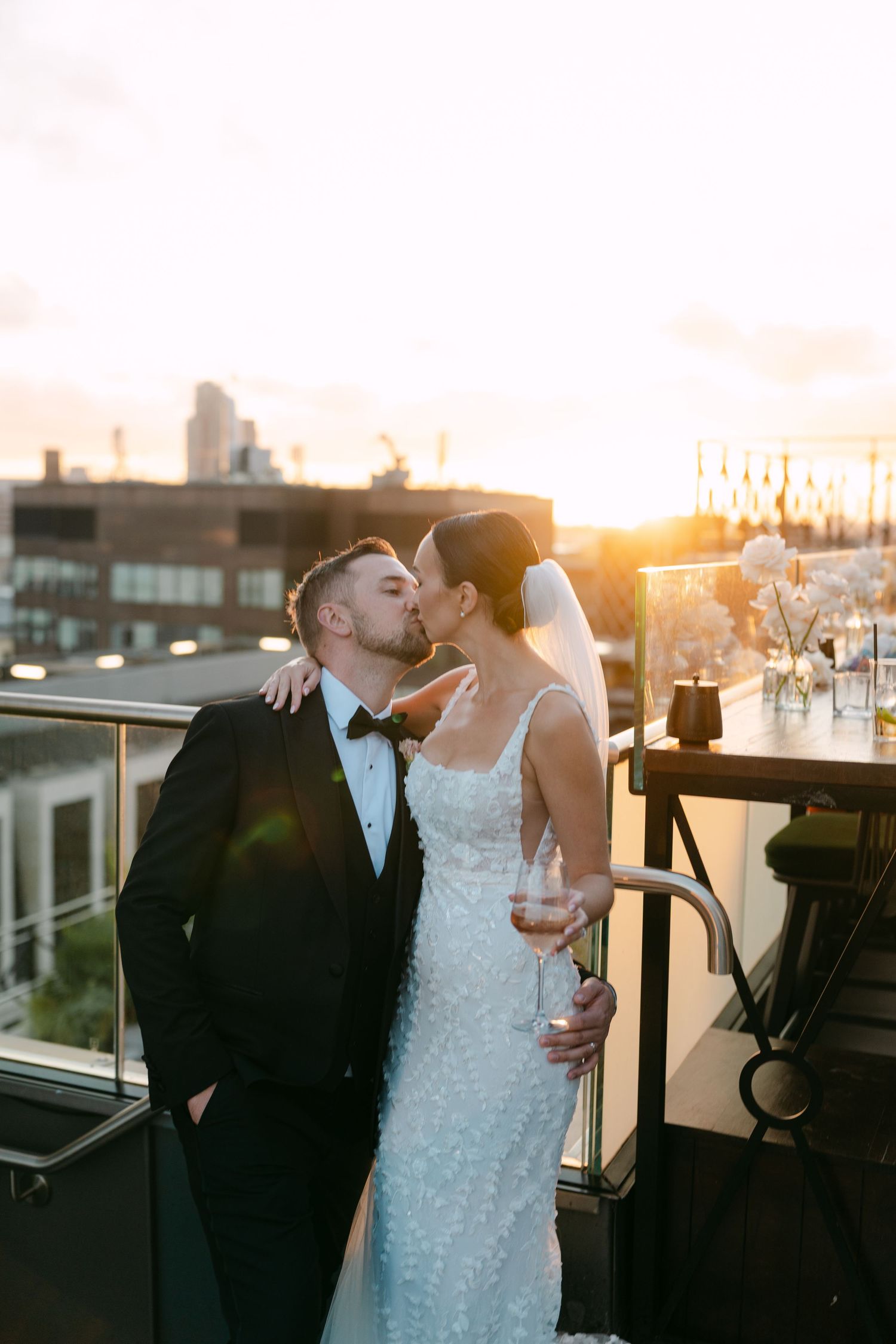 Romantic sunset wedding portraits on a rooftop terrace with city views.