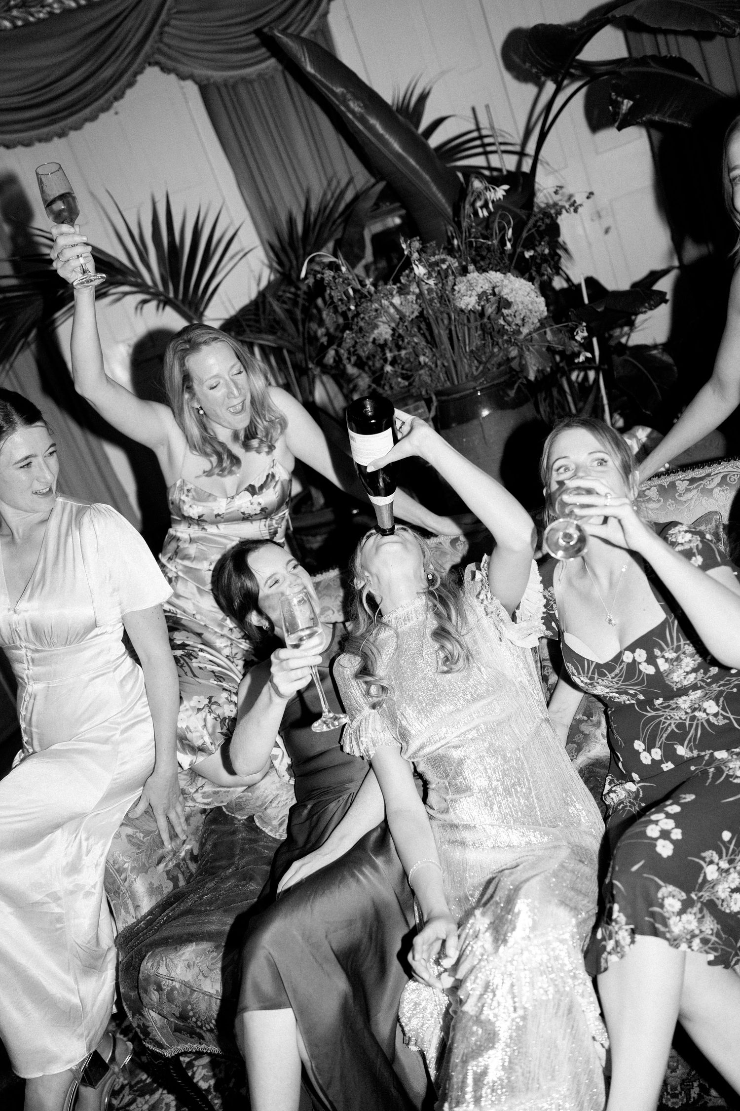 Black and white candid shot of celebration with guests in formal dresses.