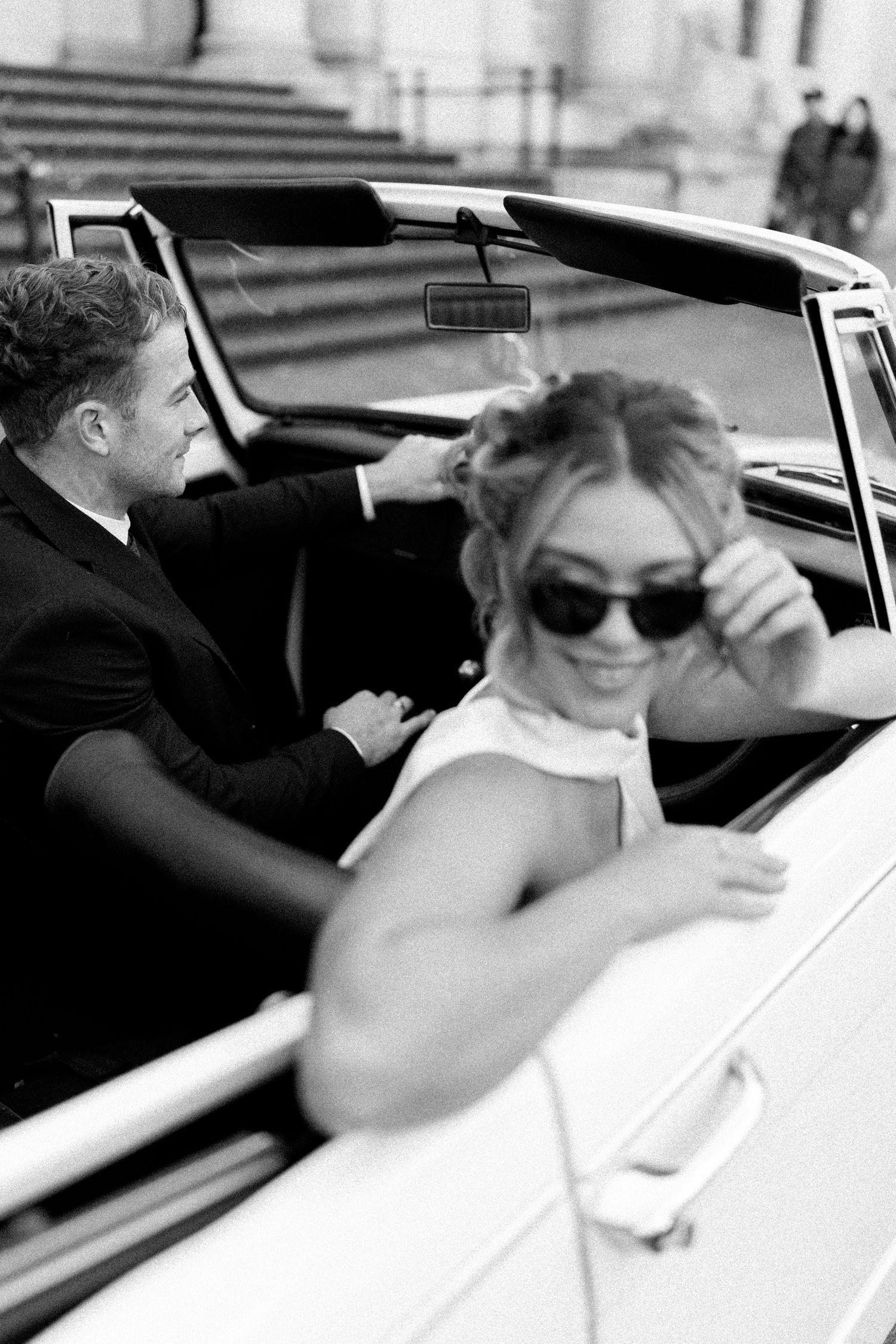 Artistic black and white photo sequence of couple in vintage convertible car.