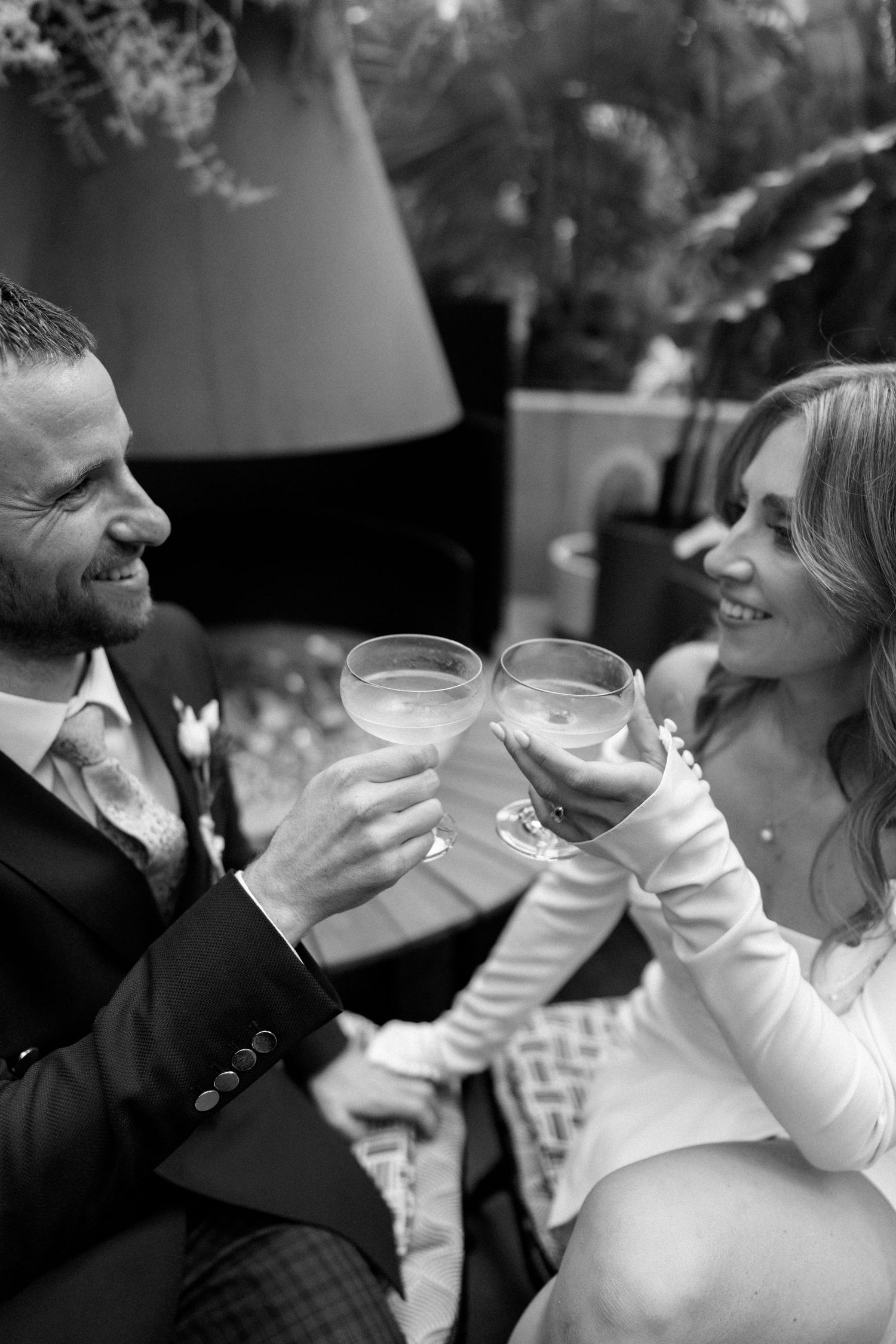 A romantic black and white photo series showing a couple sharing champagne toasts and intimate moments at a celebration.