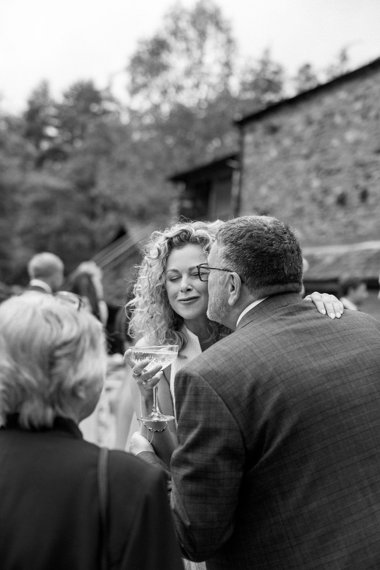 Black and white candid shots of wedding reception guests mingling outdoors.