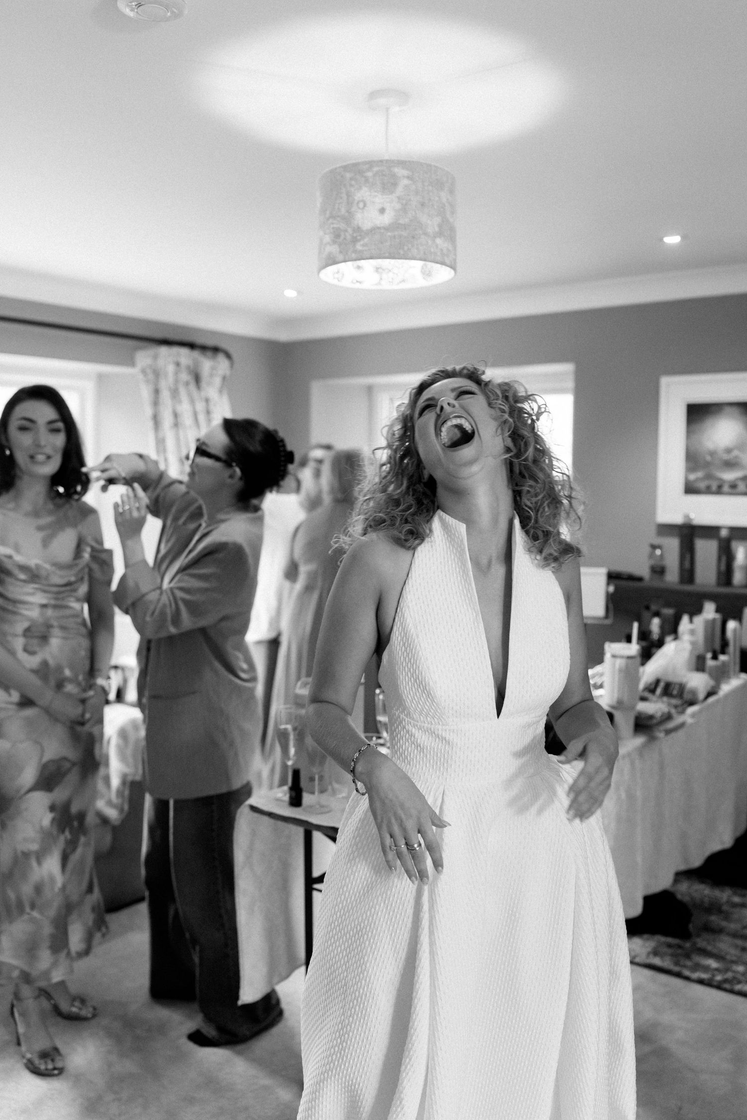 Wedding guests dancing and celebrating at an indoor reception venue.