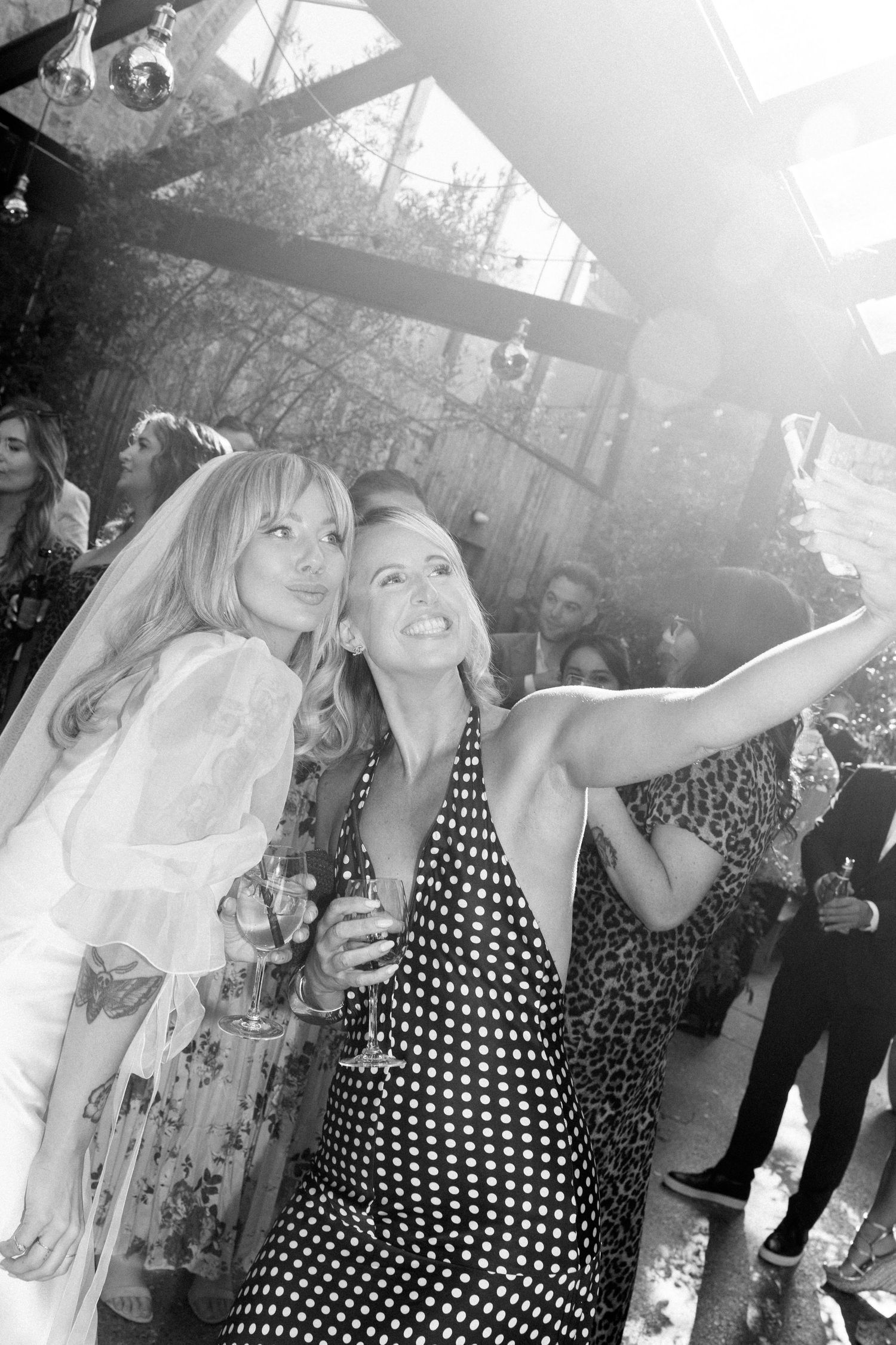 Wedding guests enjoying outdoor celebration in natural sunlight.
