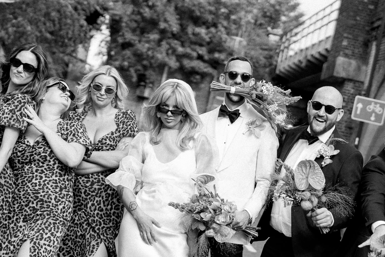 Black and white photo of wedding guests celebrating outdoors.