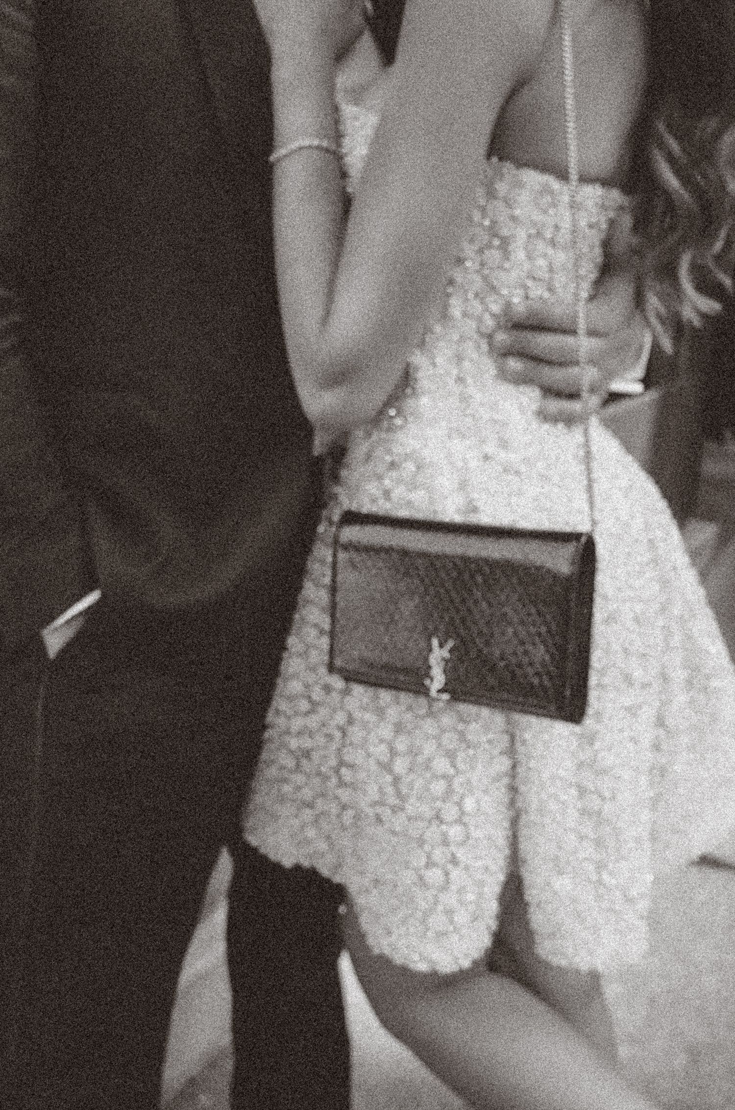 A series of black and white photos showing a white lace dress and clutch purse details at a formal event.
