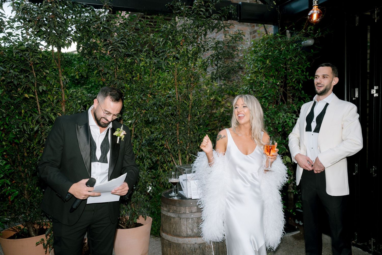 Outdoor wedding reception with greenery and string lights creating an intimate atmosphere.