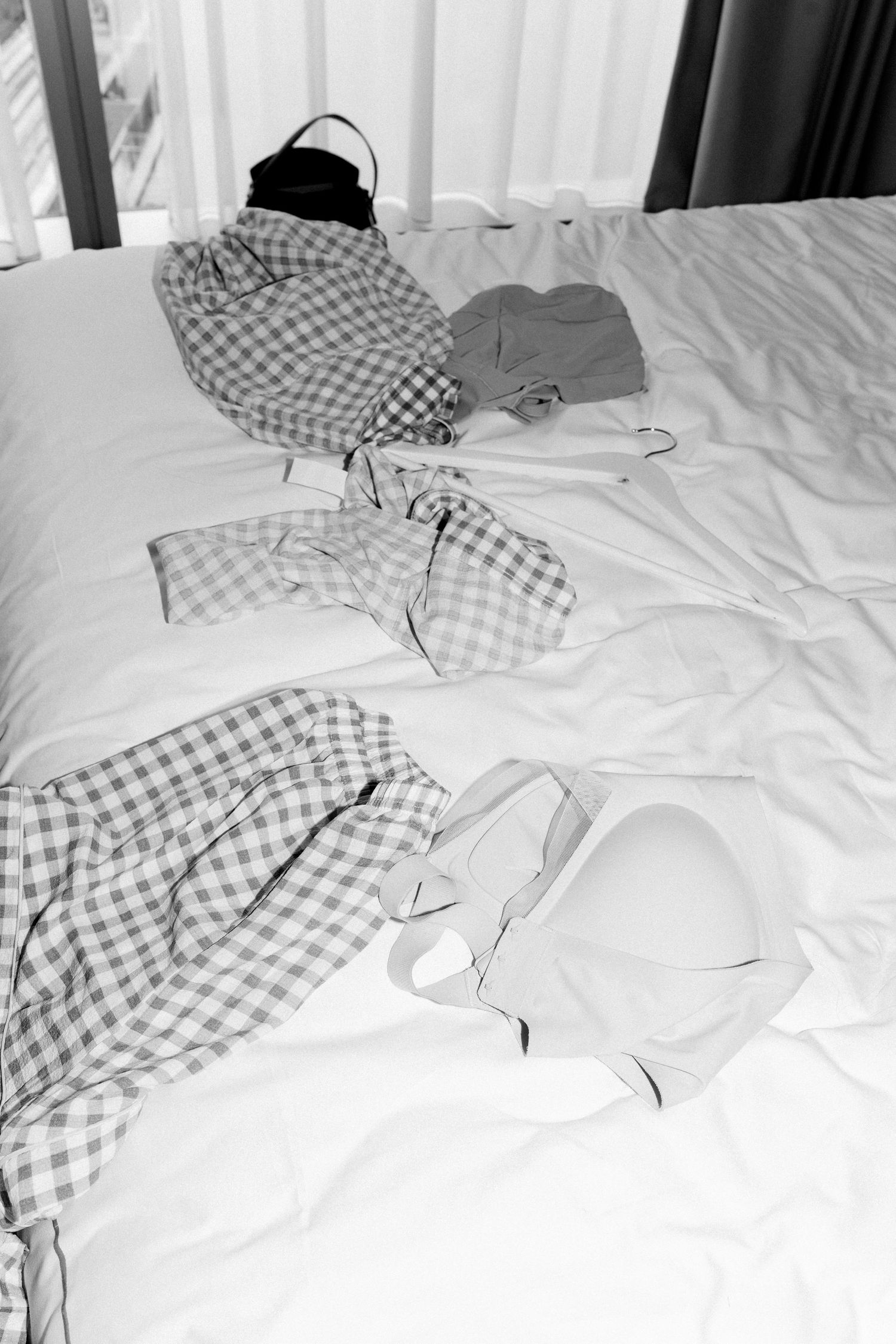 A series of black and white images showing someone reclining on checkered bedding.