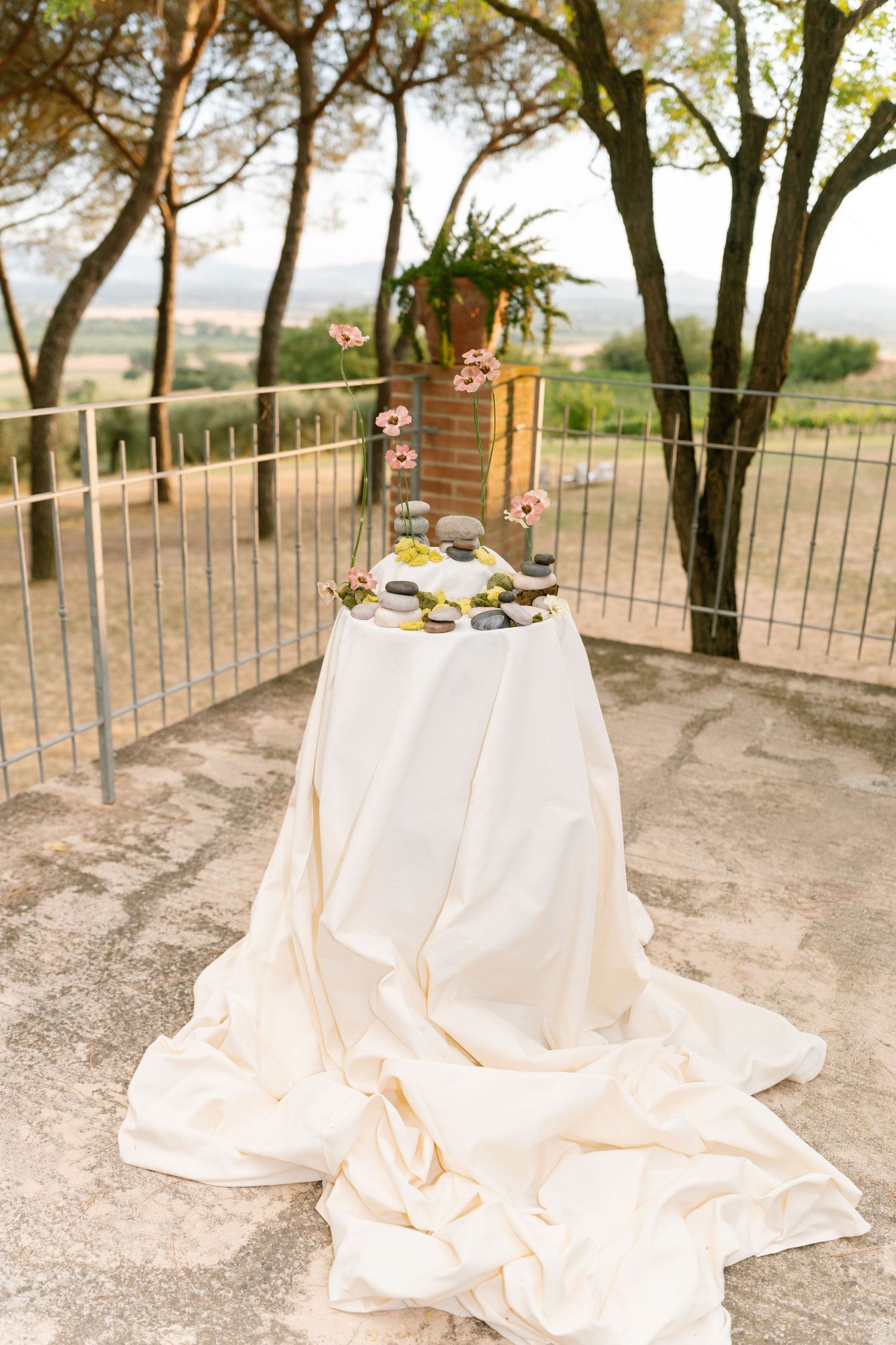 Romantic outdoor reception tables with flowing cream linens and garden views.