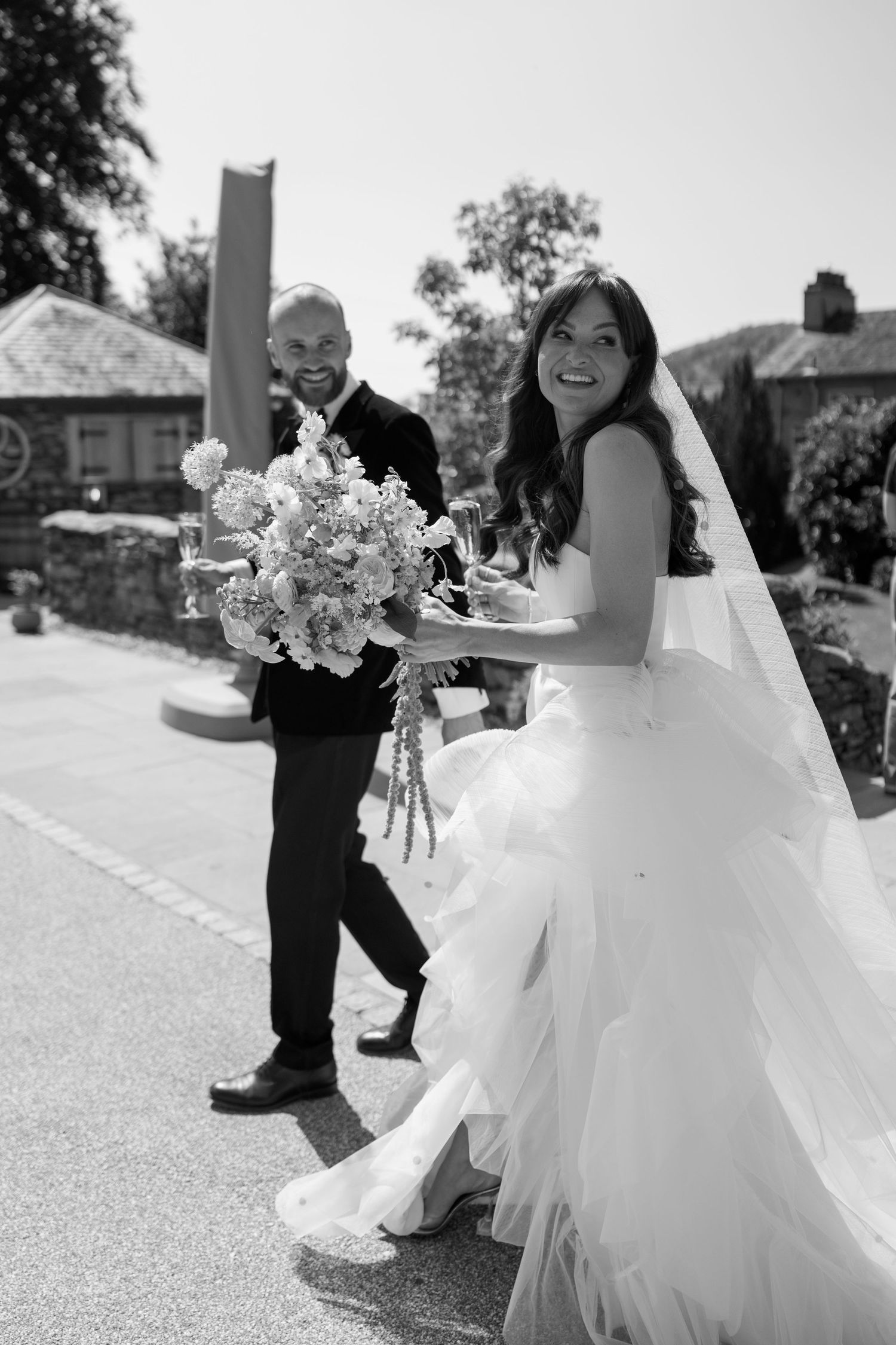 Black and white sequence showing a couple dancing joyfully outdoors on their wedding day.