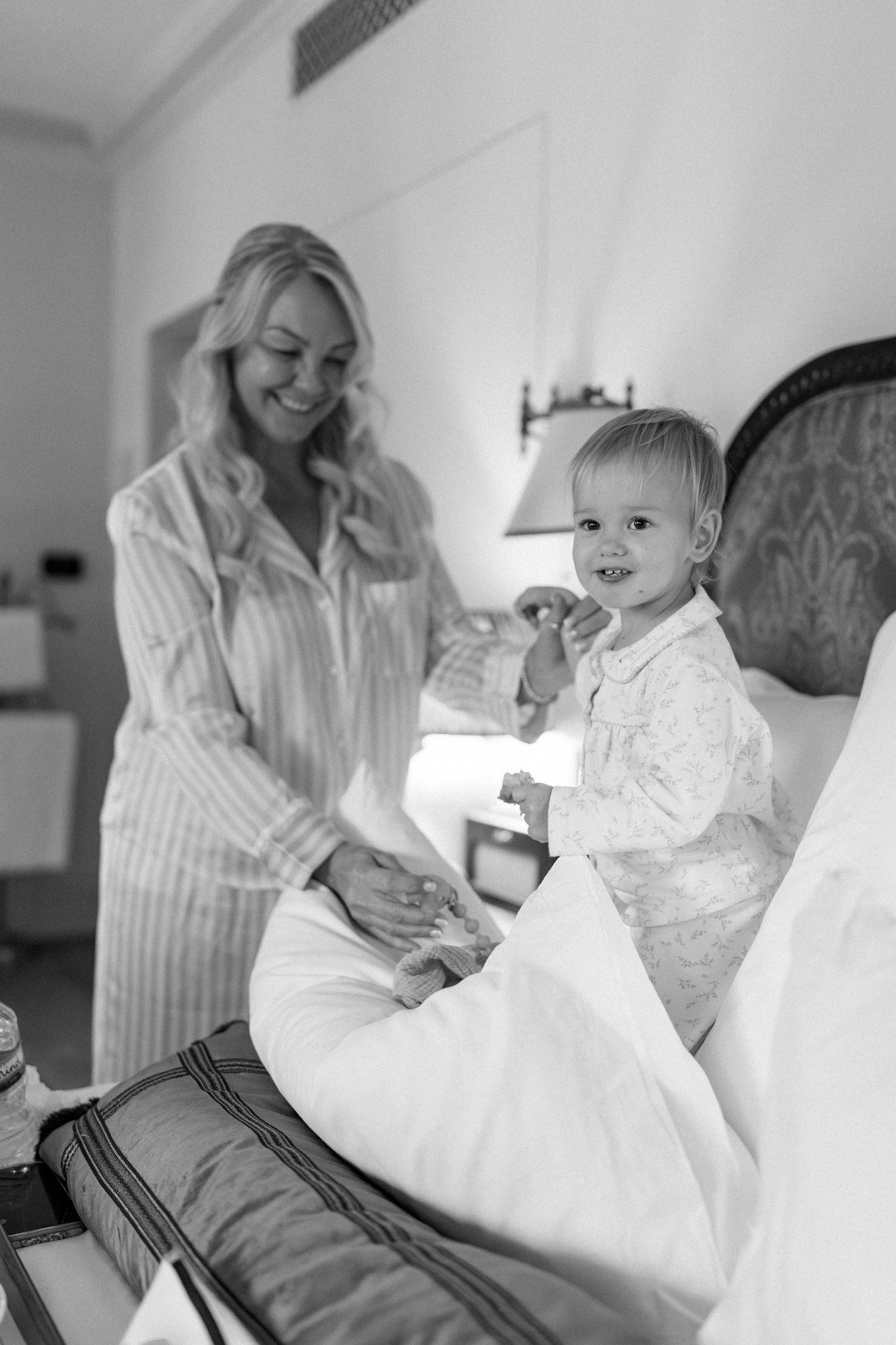 Candid moments captured in black and white on a comfortable bed.