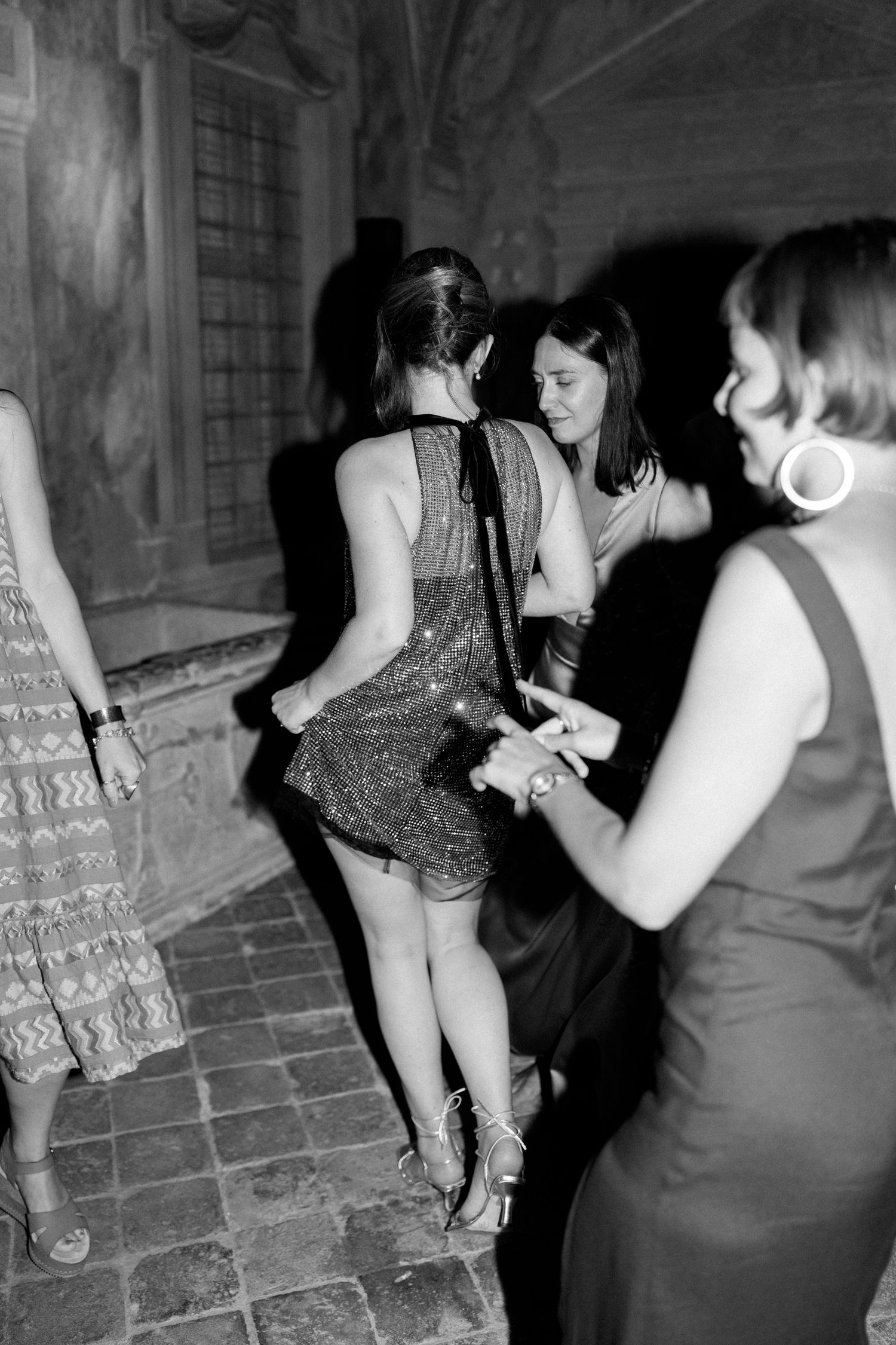 Black and white sequence showing dancers moving in a historic stone venue.