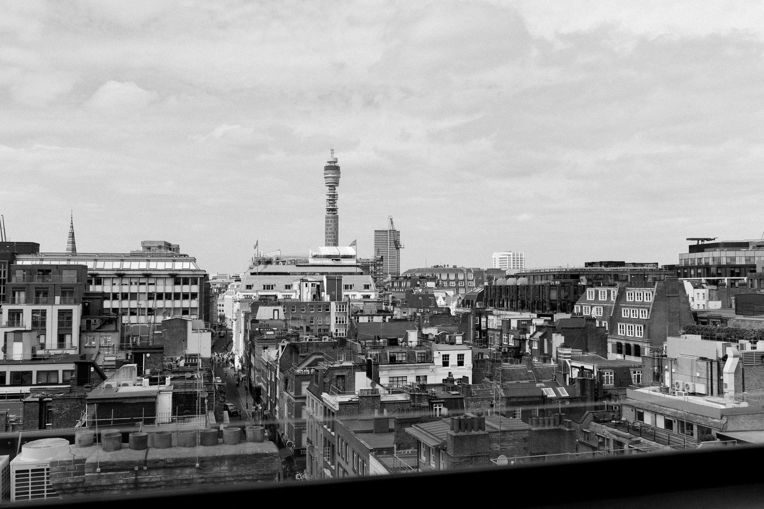 Black and white aerial view of London rooftops with BT Tower visible in skyline.