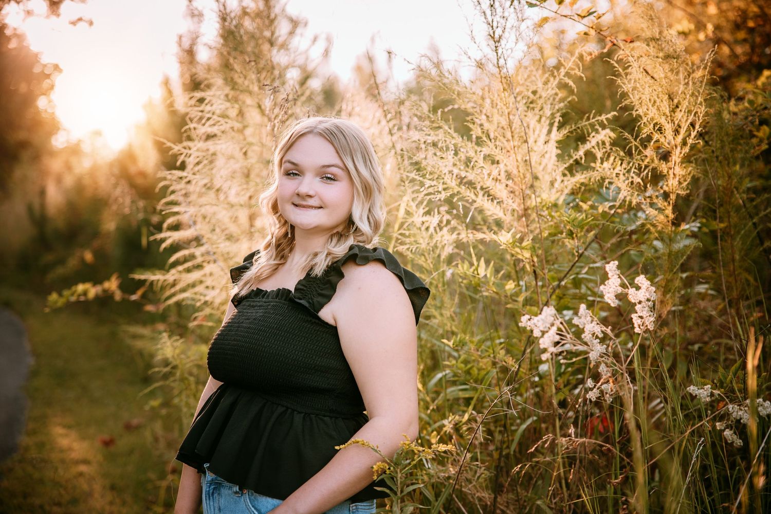 Golden hour photography session in a field of tall grass and wild flowers.