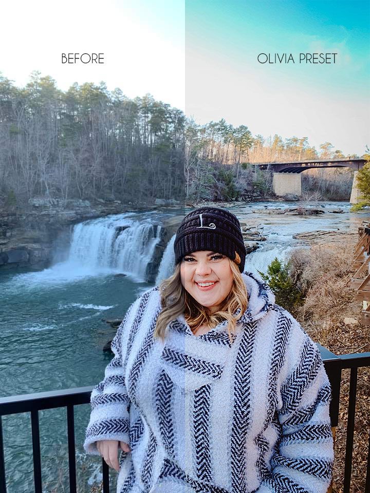 A scenic waterfall overlook with stone barriers and pine trees in the background.
