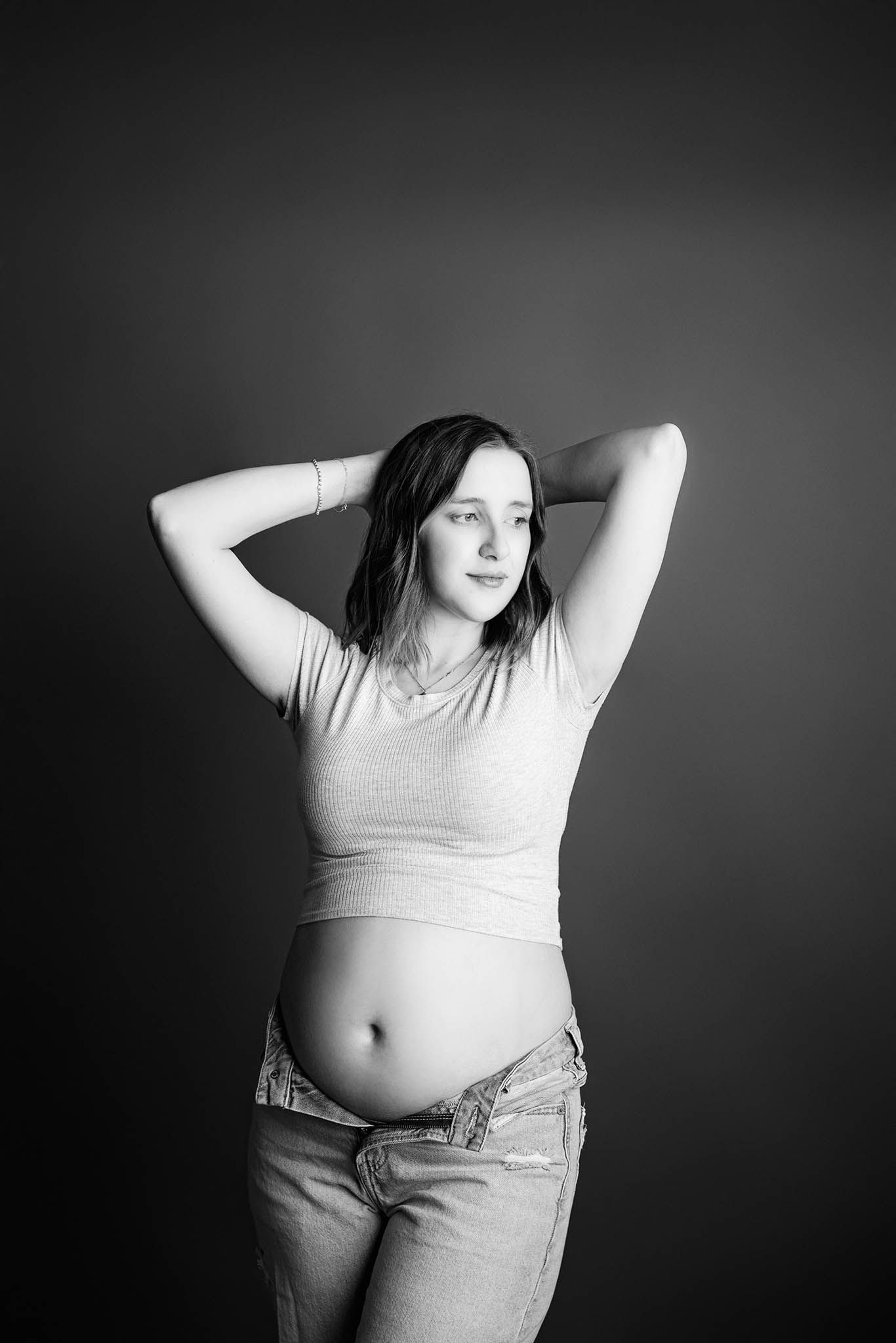 Black and white maternity portraits showing a pregnant figure in casual clothing.