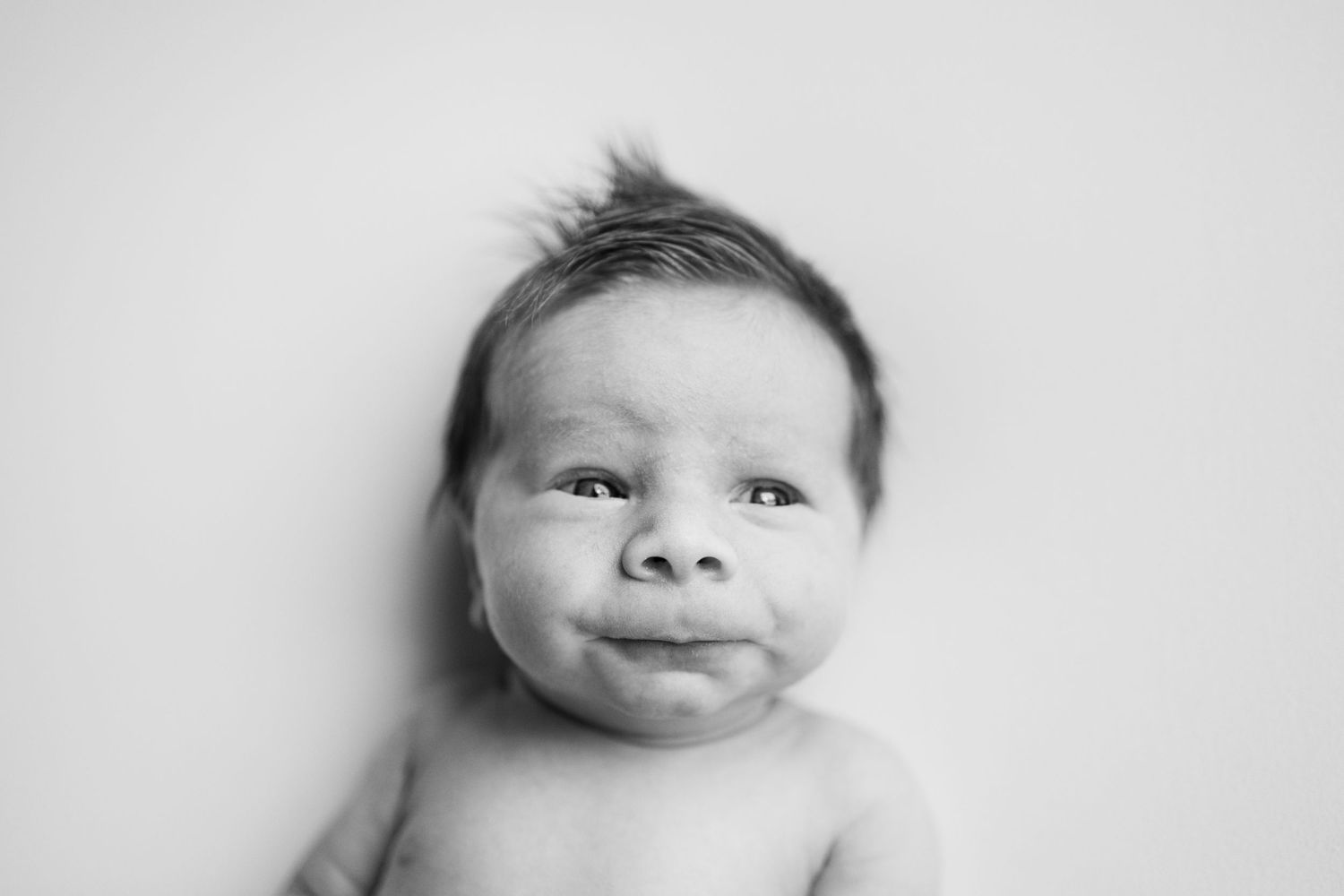 Black and white portrait series showing a baby's face making different playful expressions.
