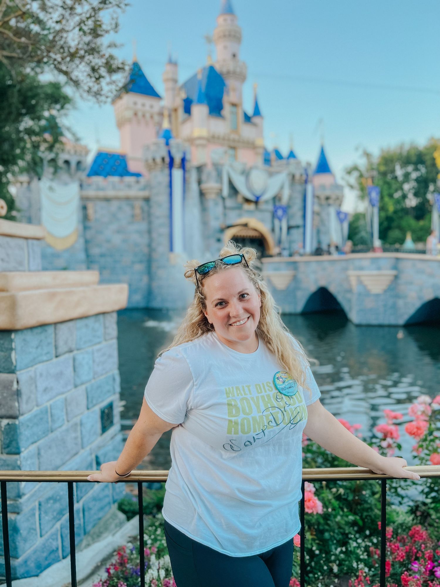 Tourist photos taken in front of Sleeping Beauty Castle at Disneyland with blue spires and flowers.