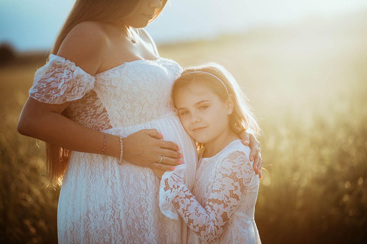 Sunlit maternity photos featuring delicate lace details and soft natural lighting.