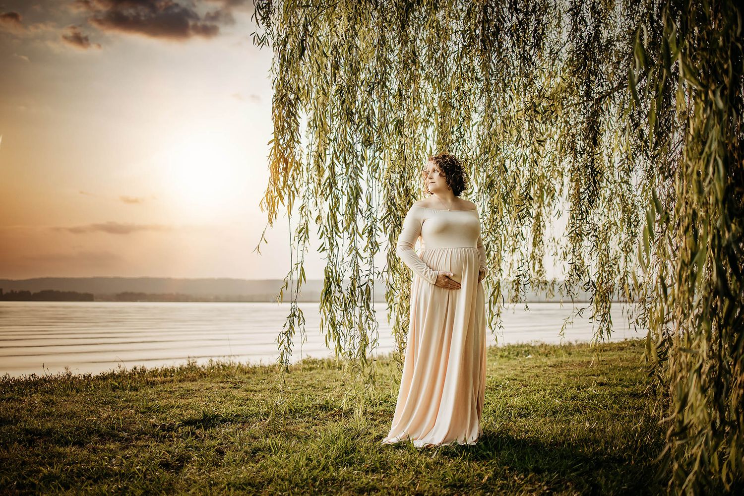 Dreamy outdoor photoshoot under drooping willow trees at golden hour.
