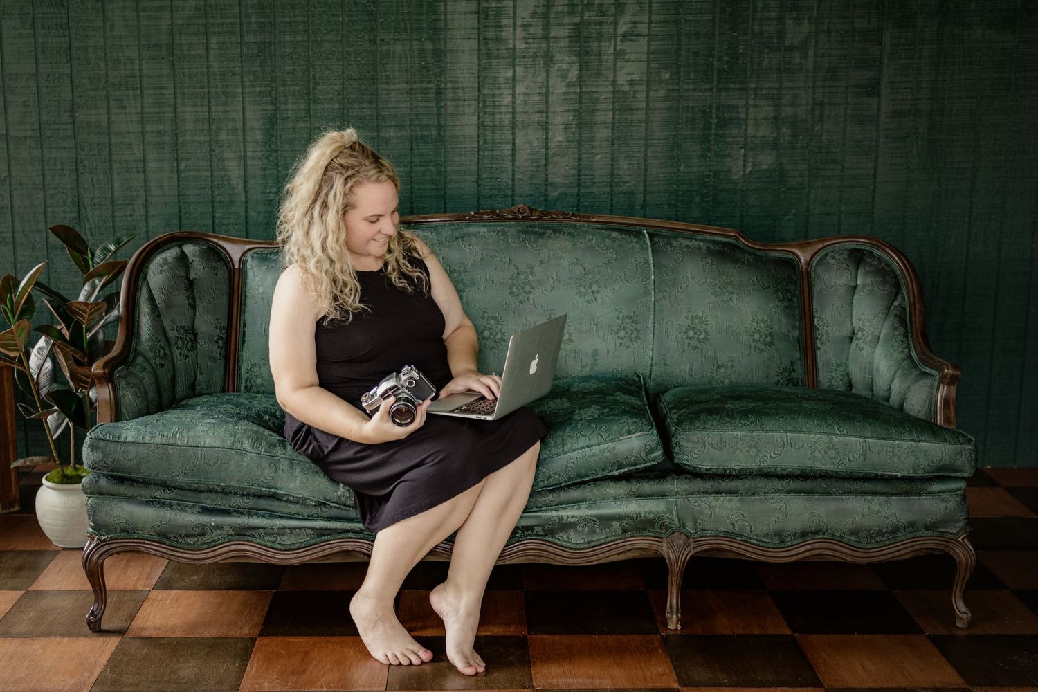 Artistic portraits on a vintage velvet couch in moody lighting.