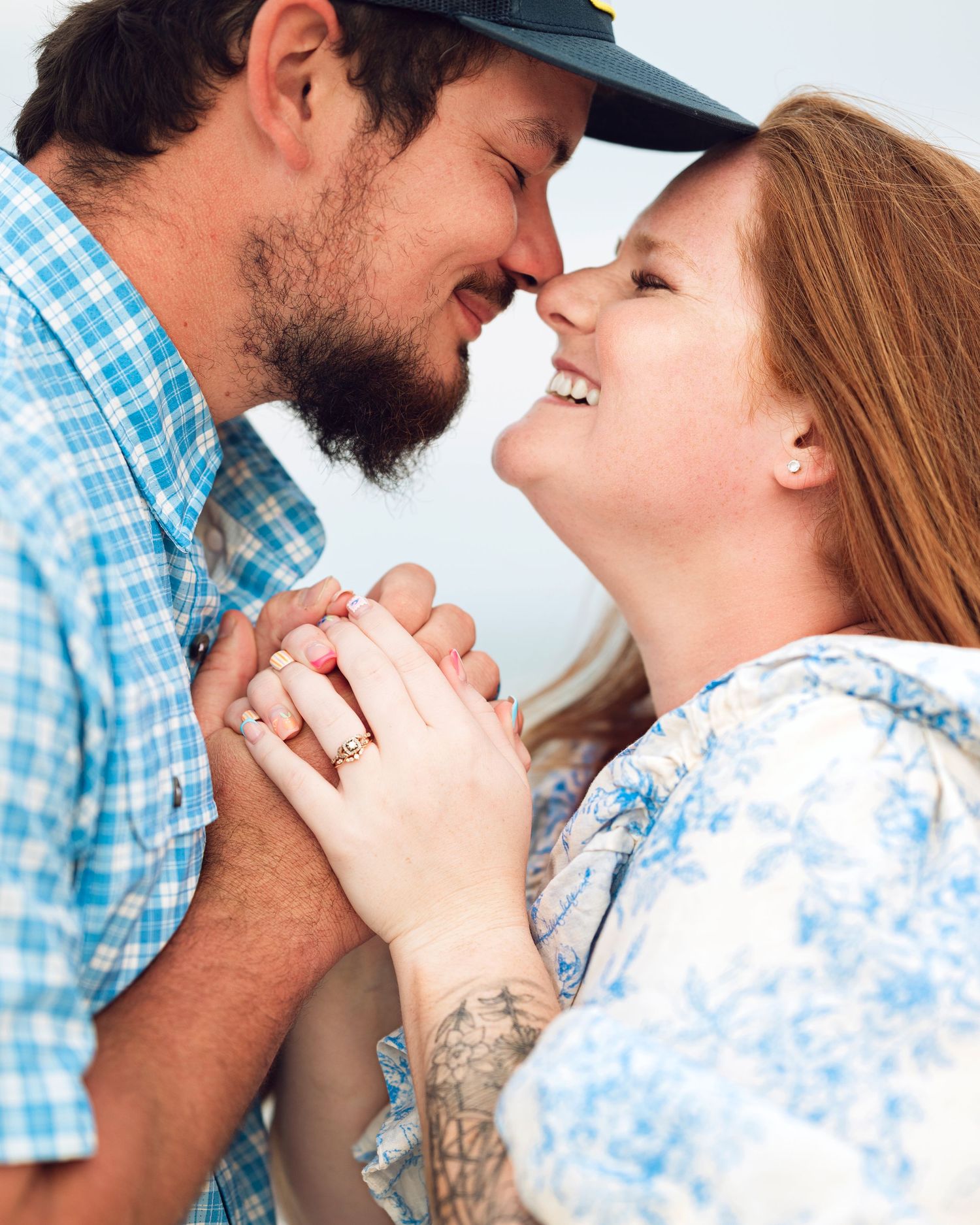 A romantic couple shares an intimate moment while holding hands outdoors.