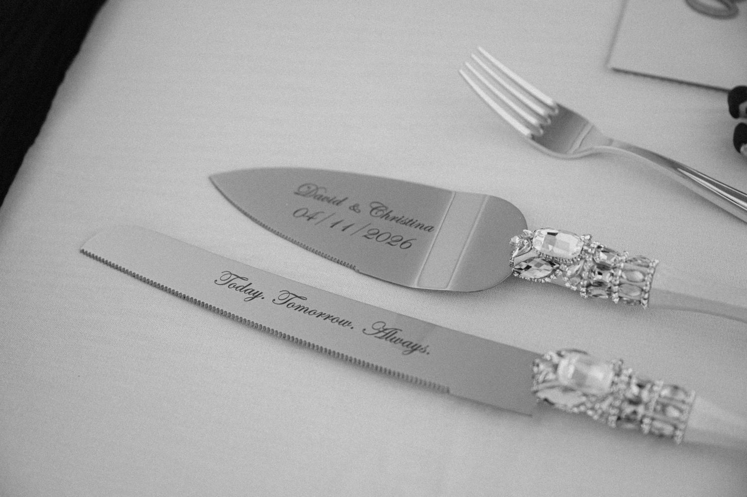 Elegant wedding cake server and knife set with pearl handles and personalized engraving on white tablecloth.