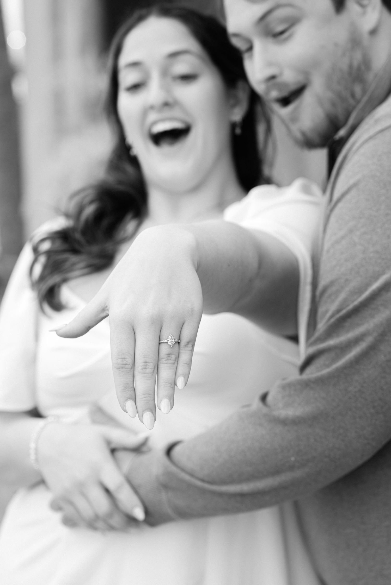 A joyful black and white moment displaying an engagement ring.