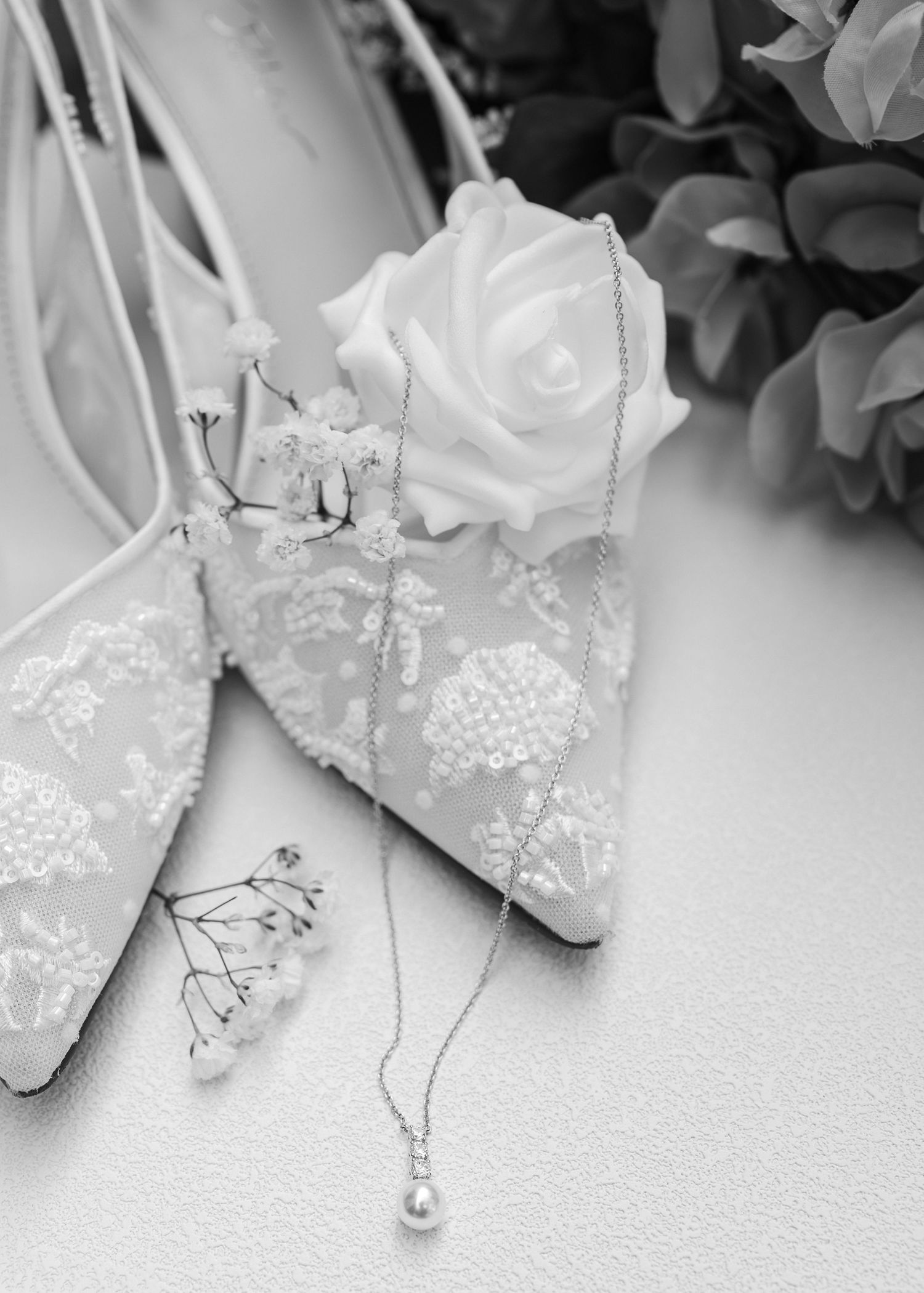 Elegant white lace wedding shoes with delicate beading and embellishments displayed in a row.