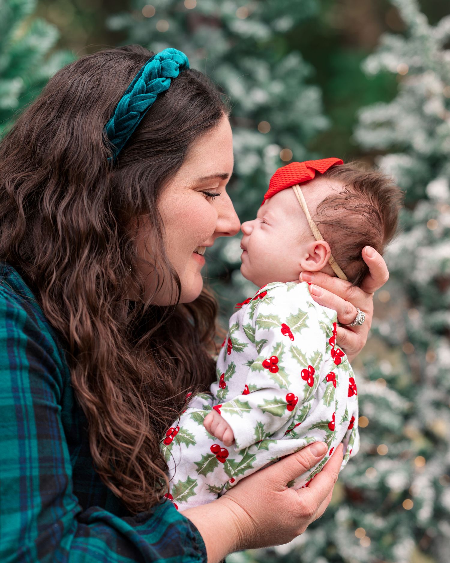 Sweet family moment outdoors with floral clothing and plaid shirt against blooming background.