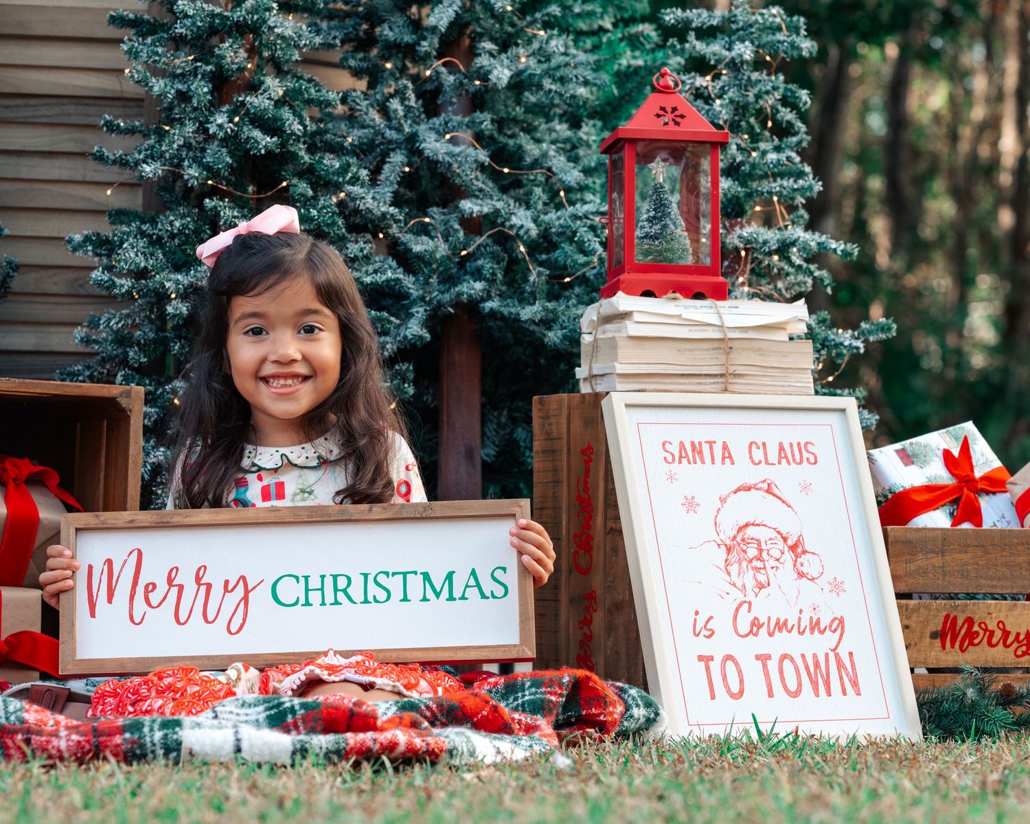 A festive holiday scene with a Merry Christmas sign and Santa Claus is Coming to Town decoration.