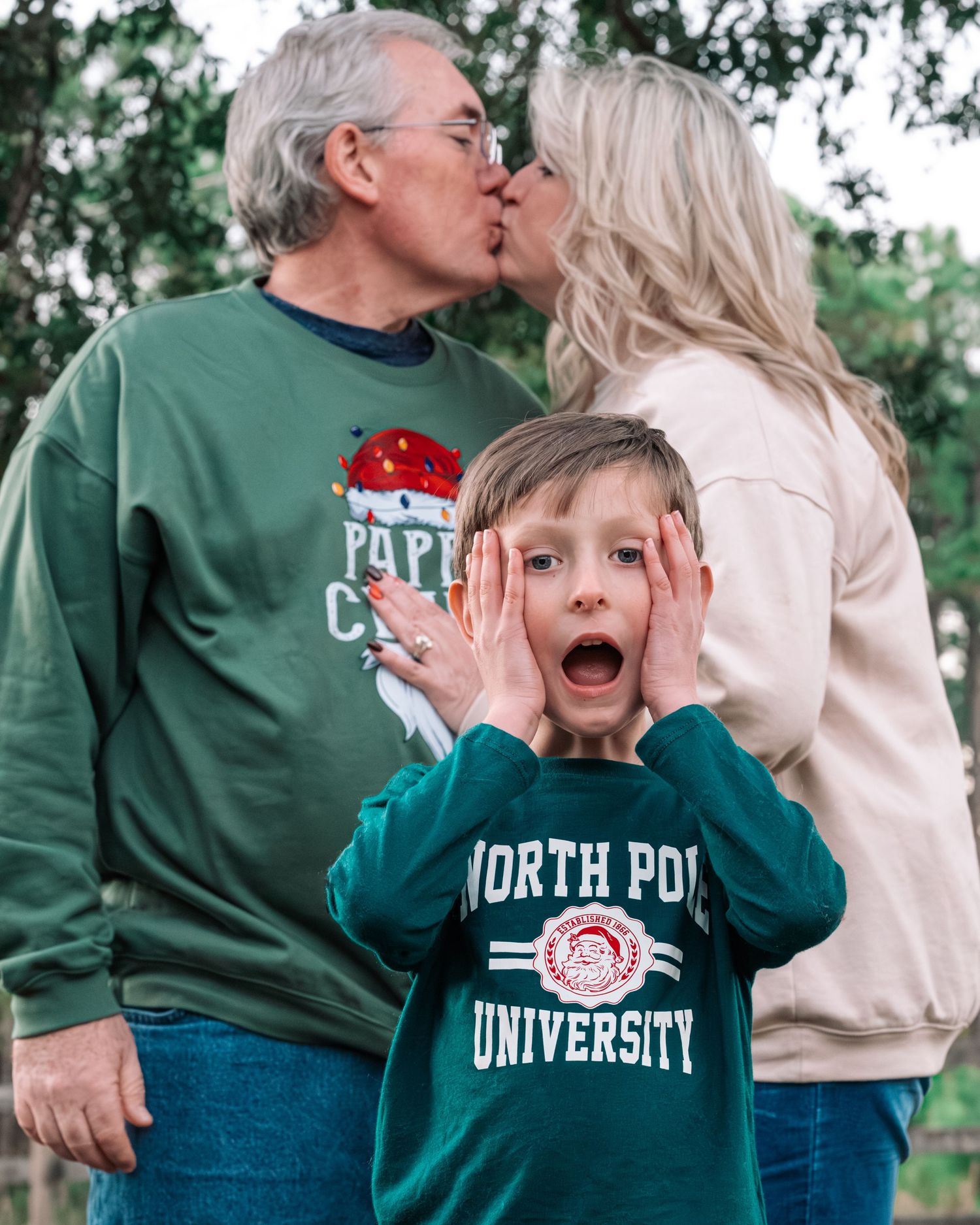 A playful family moment captured outdoors with North Pole University apparel and holiday spirit.