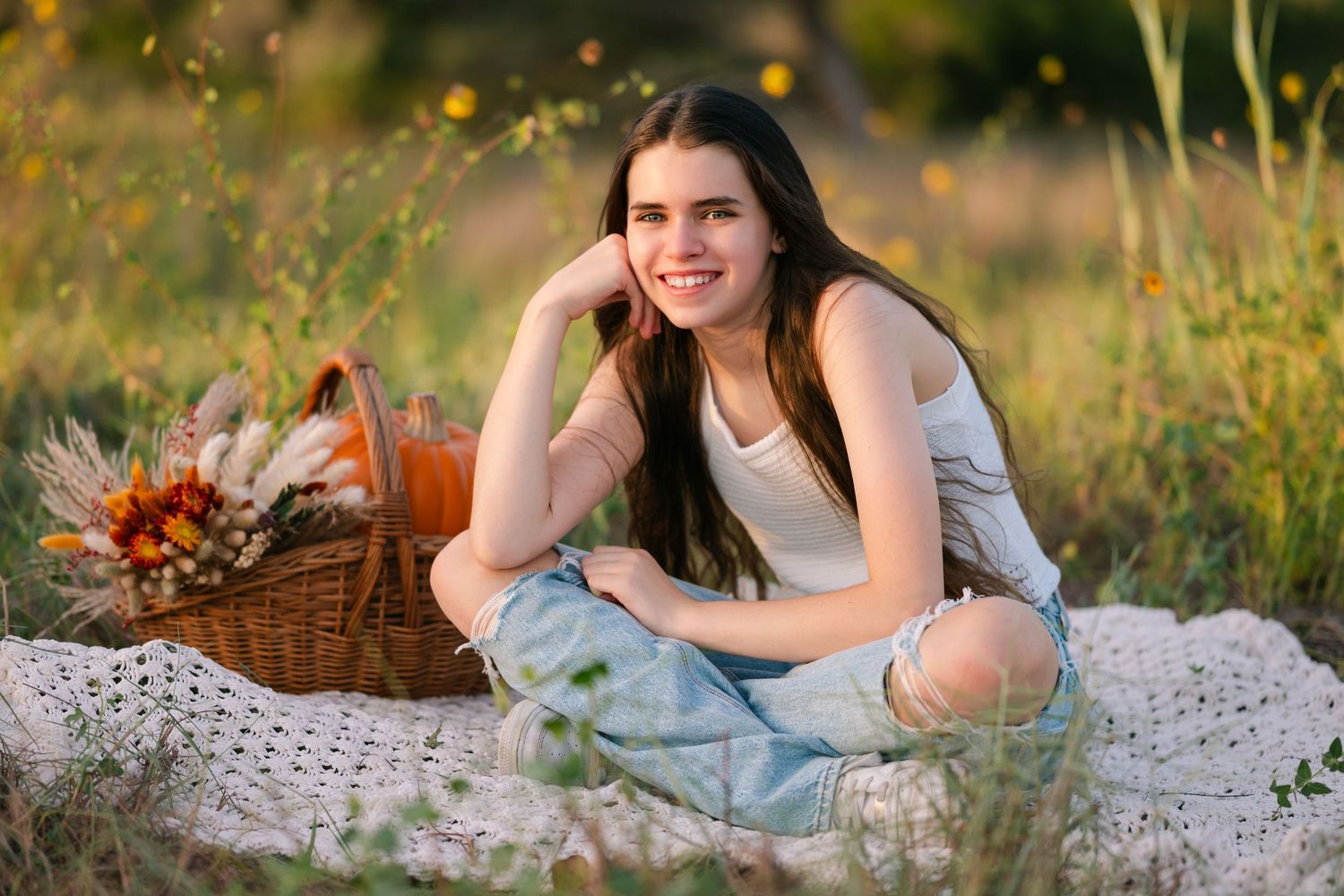 Casual outdoor picnic setting with plaid shirt and white blanket in grassy field.