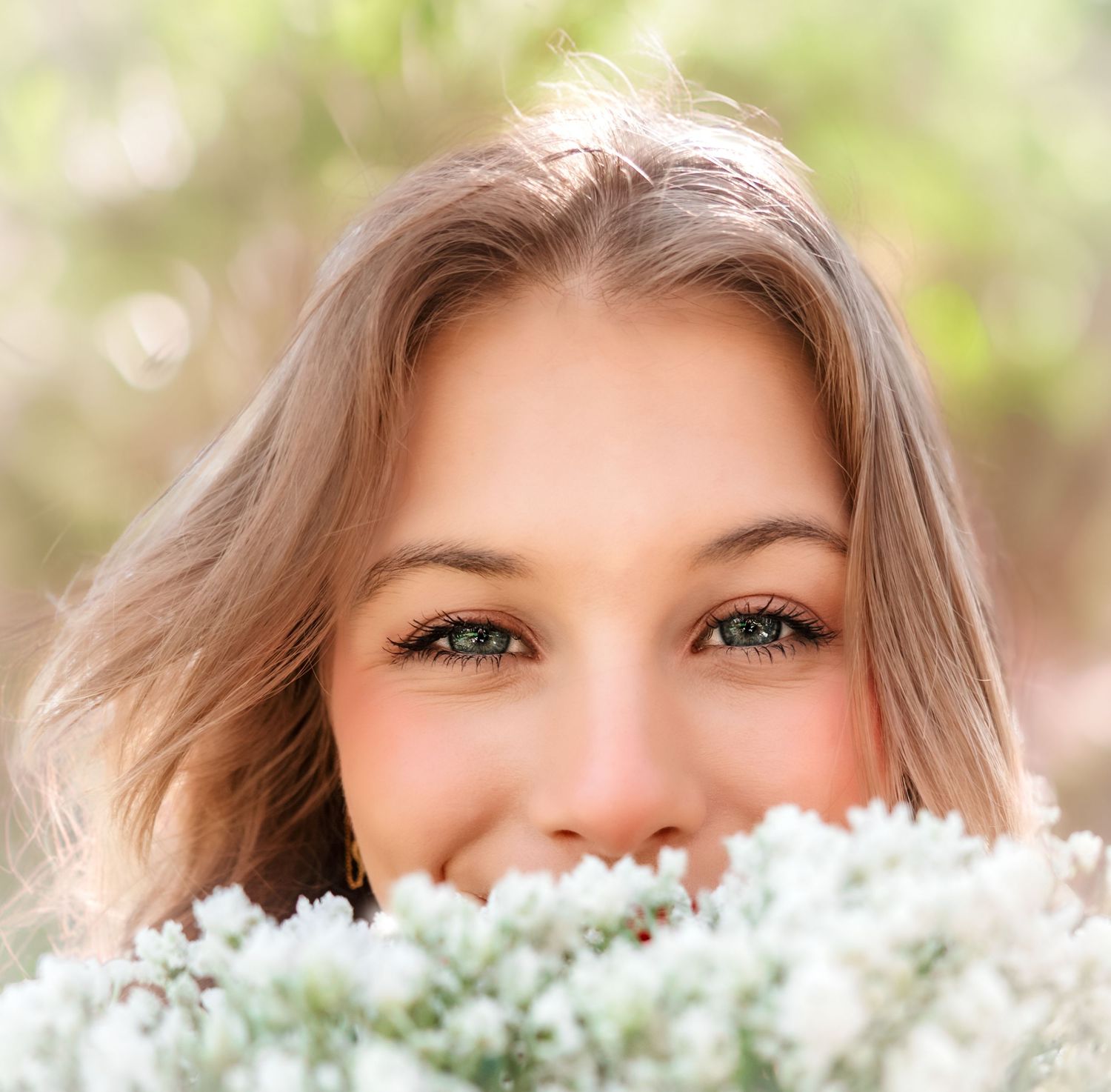 Close-up portrait with white flowers creating ethereal spring mood.