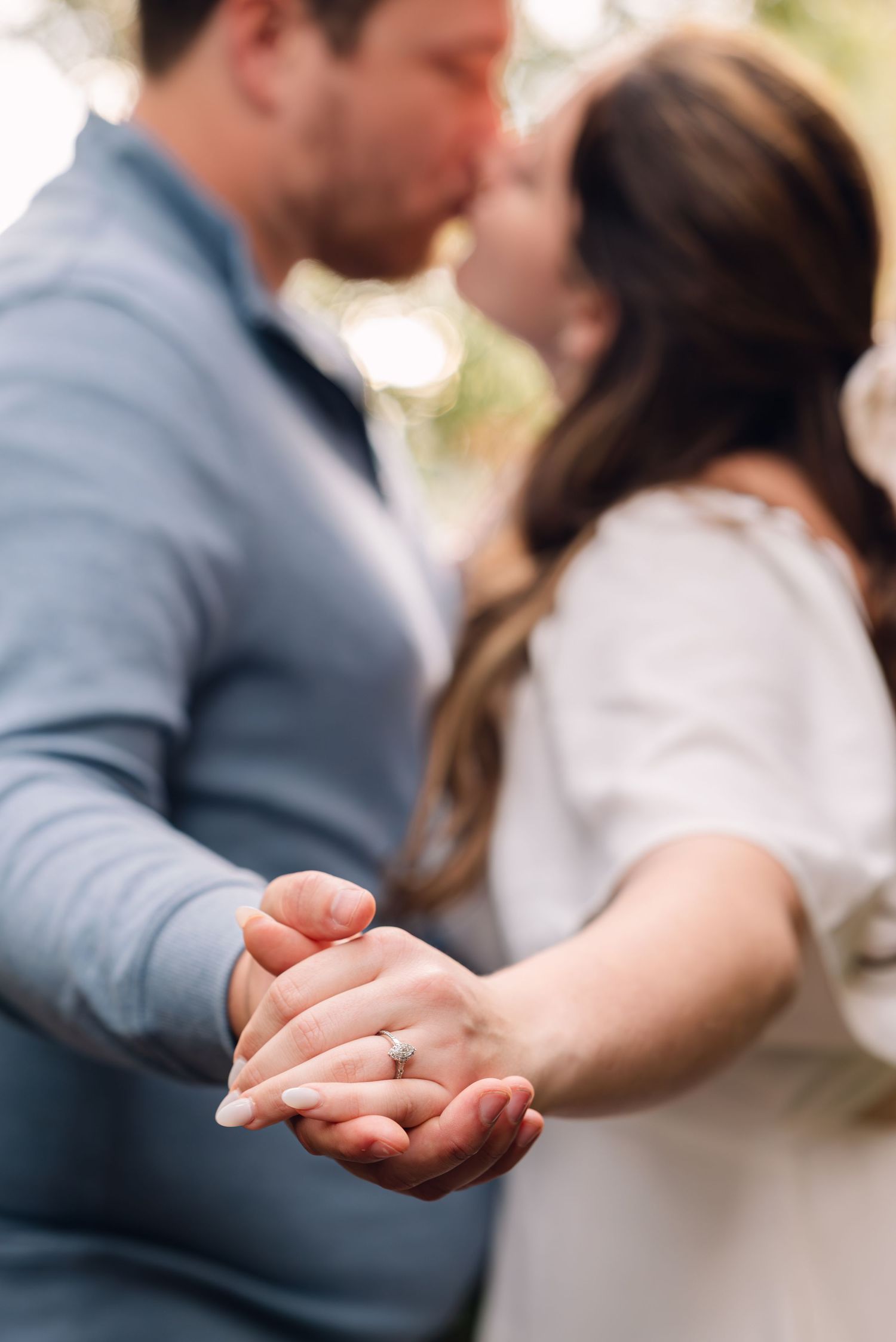 A tender romantic moment showing clasped hands with an engagement ring.