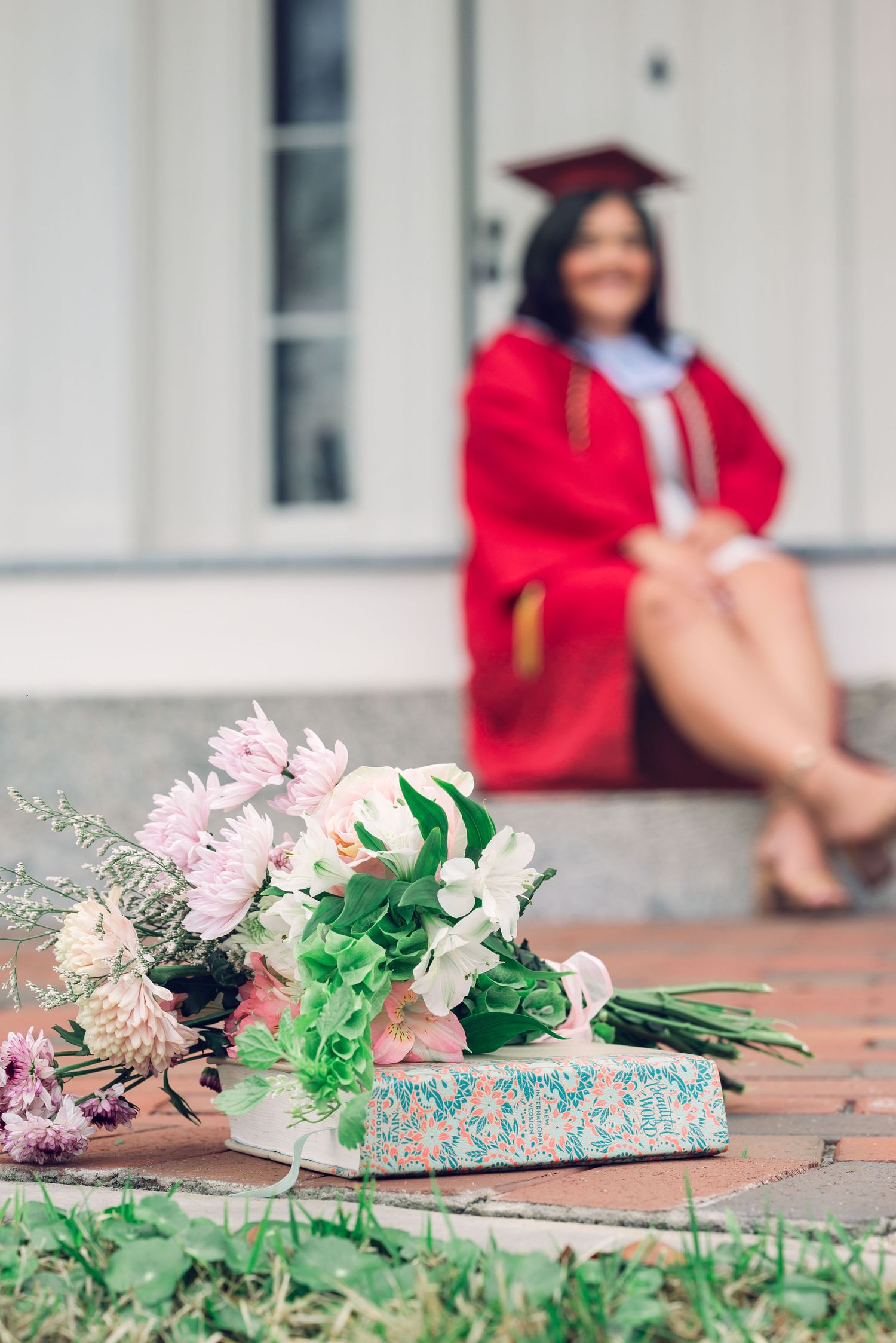 Pink flowers and graduation caps lie scattered on red brick pavement during a graduation ceremony celebration.
