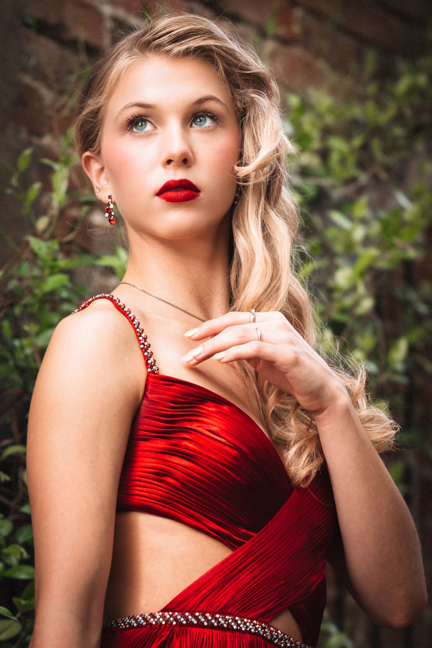 Glamorous red satin evening gown with cutout details and vintage-inspired styling.